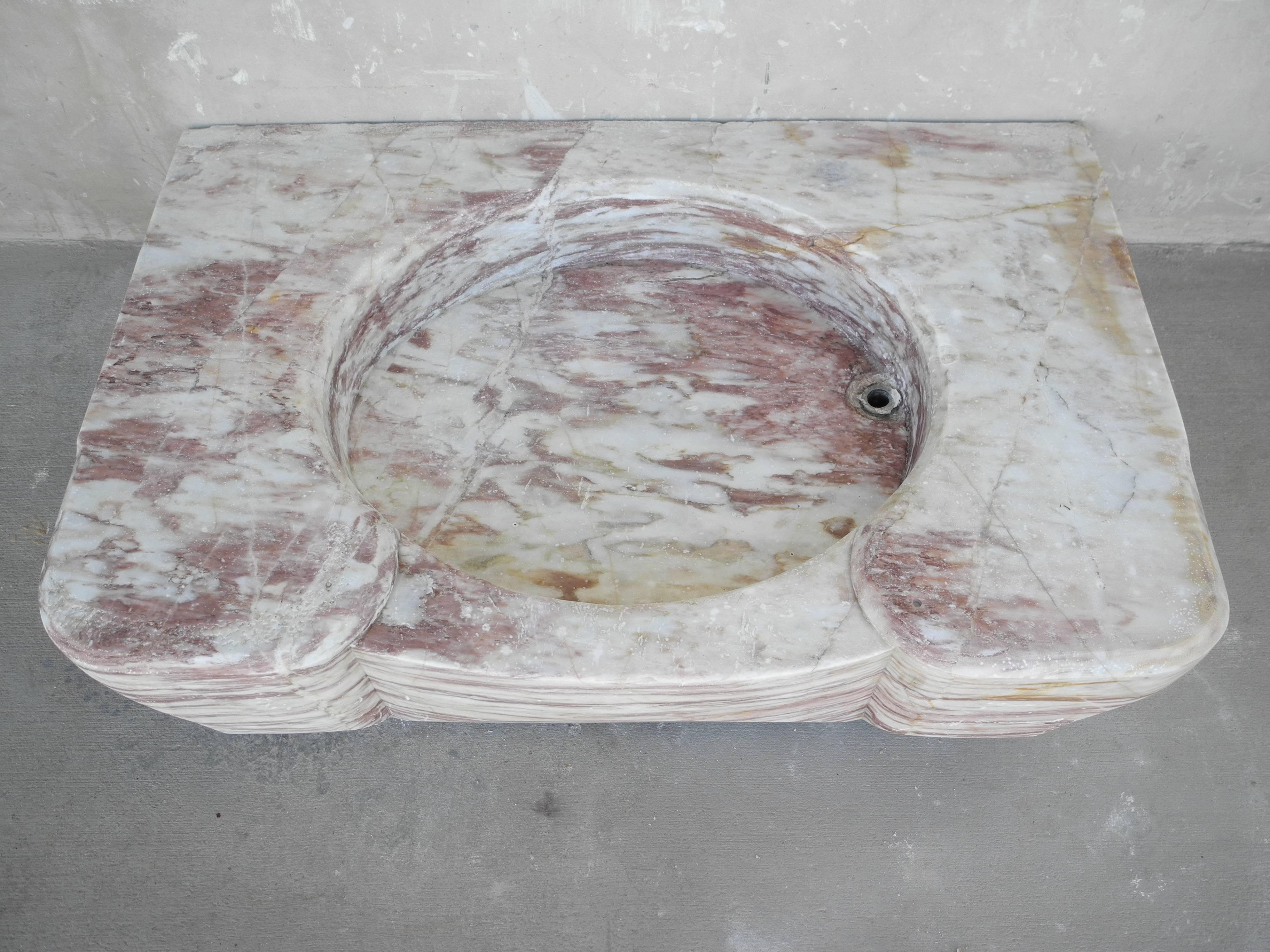 This is an antique 18th century marble evier sink from an elegant "bourgeoise" country house in the "Montaigne Noire" of the Pyranees. It is made of marble, which includes lovely red veining. It is carved beautifully, with some
