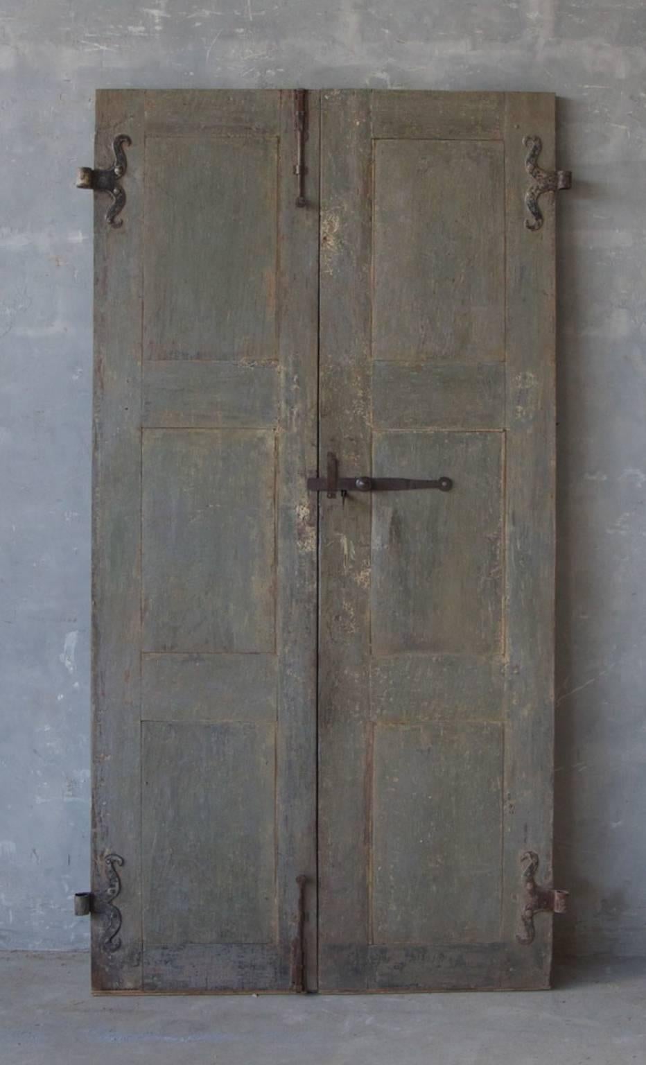 This is a minimally lovely pair of 18th century Tuscan doors. Their elegant blue color and large size make them perfect for any space. They have old reclaimed hardware made of iron and simple carving. 