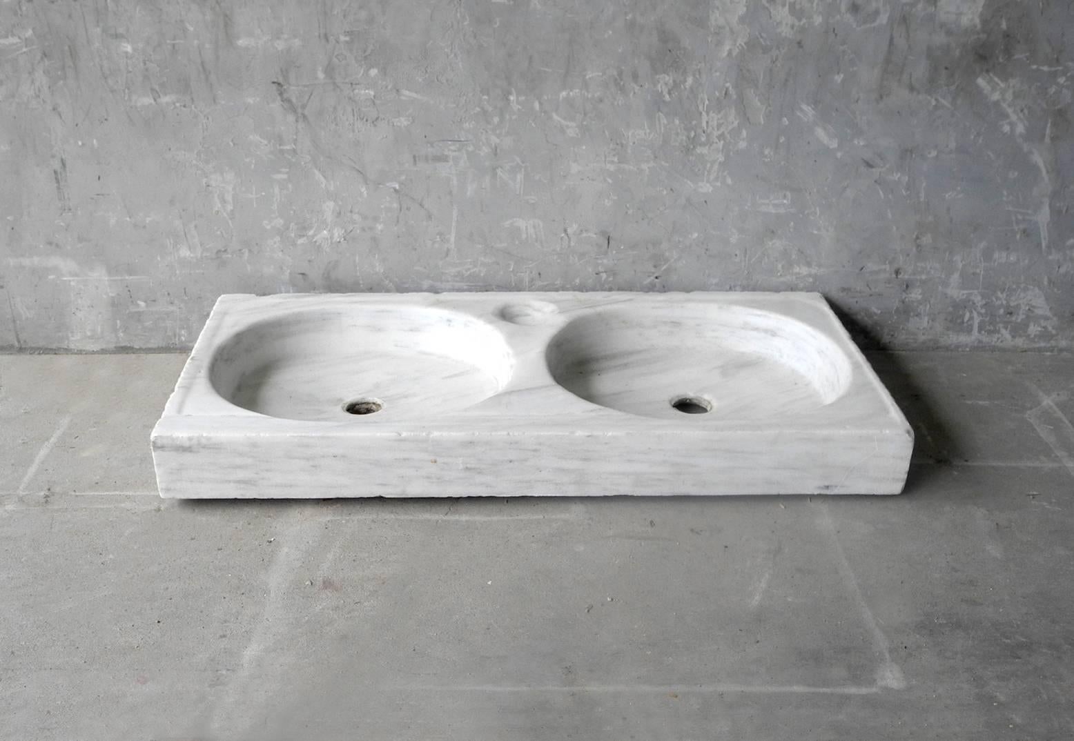 This 18th century item is double white marble sink from a bastide in Provence. It is luxurious in feel due to its material. It is very large in size - working well in a master bathroom. It is in wonderful condition, with barely any patina or aged
