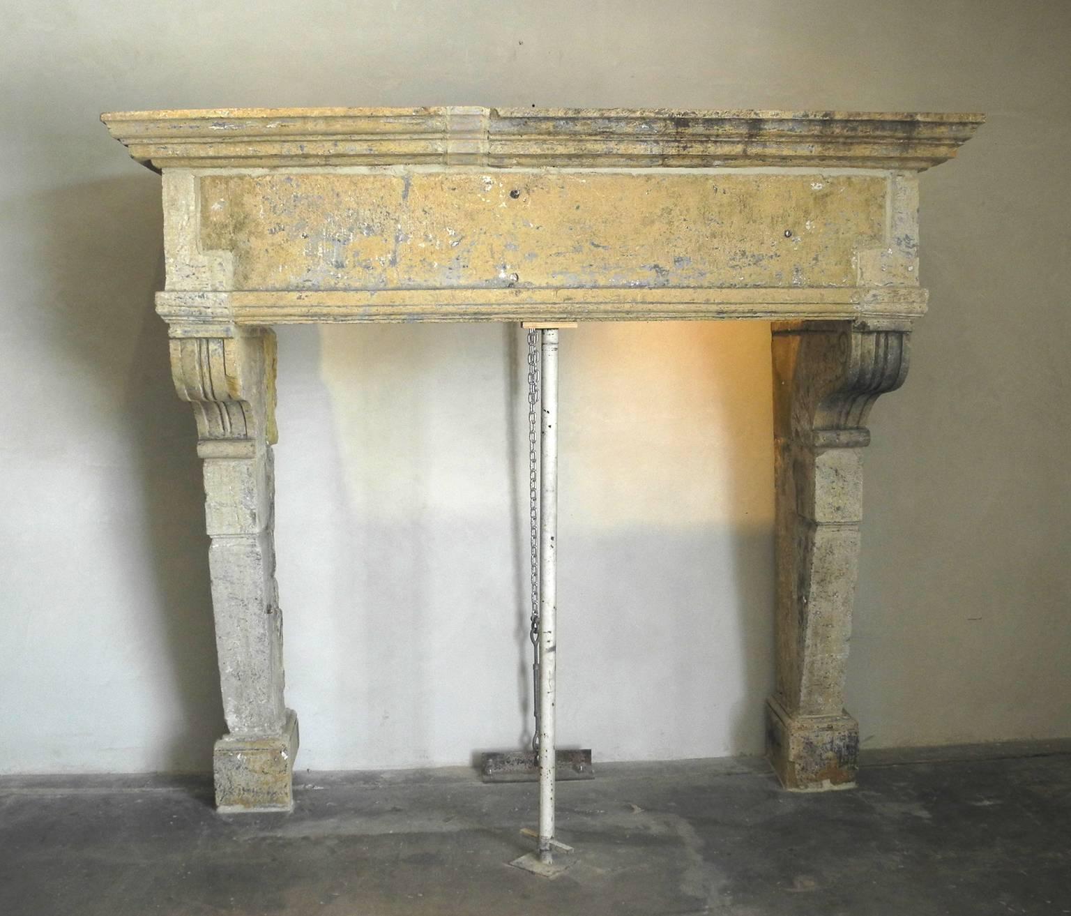 This is a very large stone mantel from early 17th century, France. It boasts a creamy patina and carved top, lintel, and legs. The carvings give it a very luxurious feel. It is the perfect centerpiece to any formal living room.