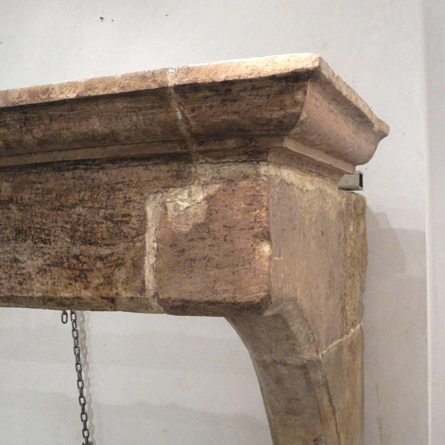 This is a grand fireplace mantel that features carved legs and lintel. It is from the 18th century from Ainsi, a town on the French-Swiss border. Due it its size, it is a great centerpiece for any room, or great atop a stove.