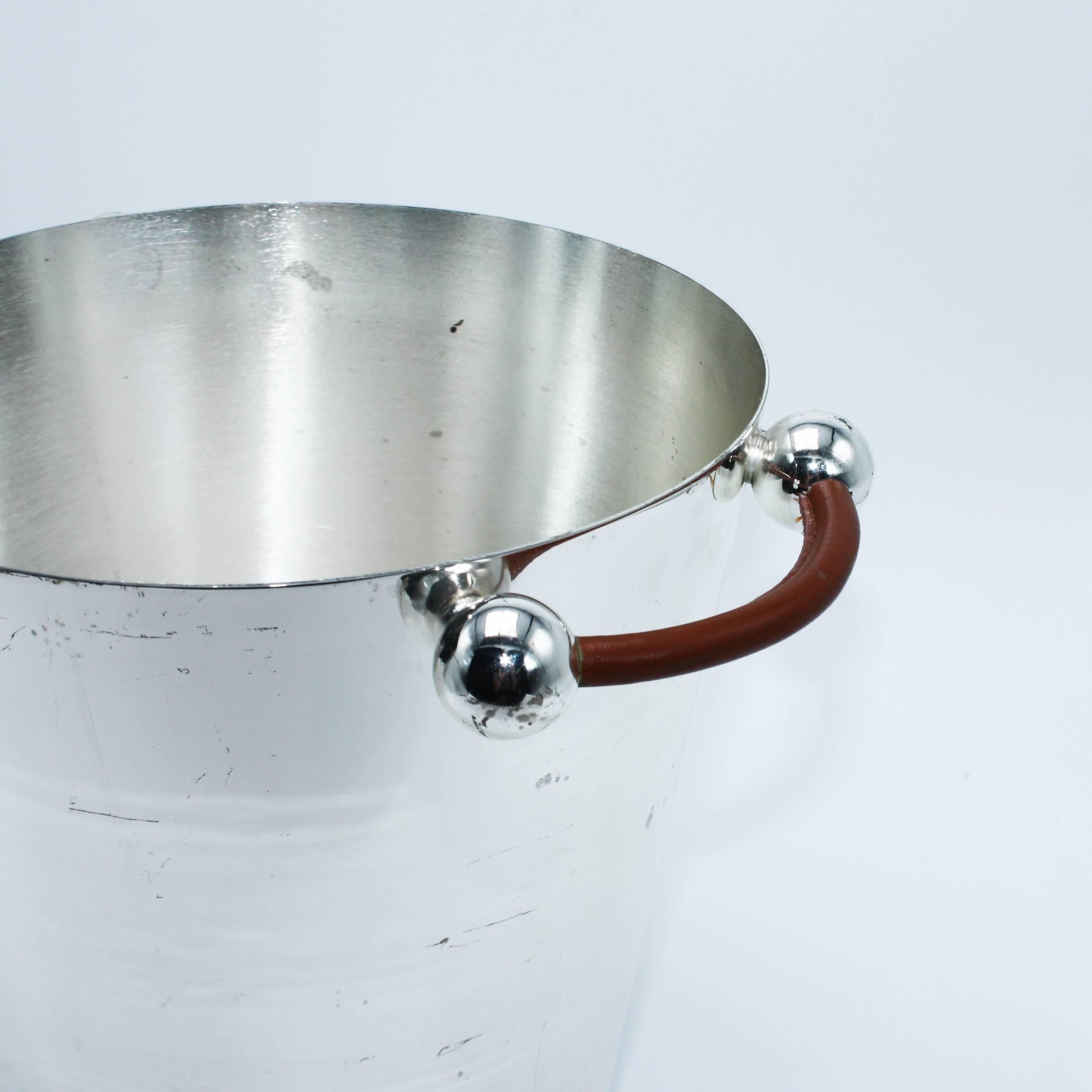 Silver plated ice bucket with tan leather handle, circa 1960.
    