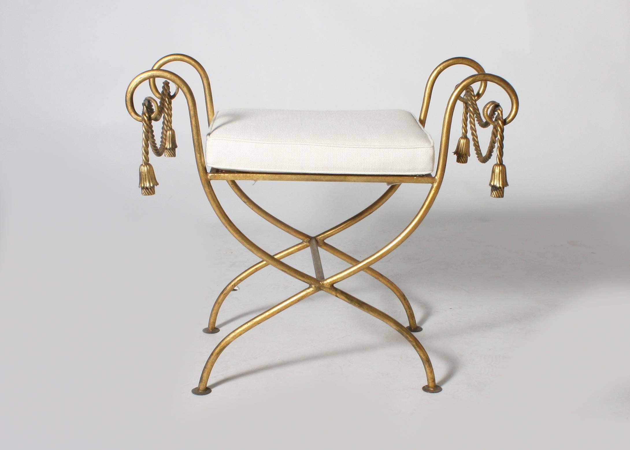 French gilded iron dressing bench with an ivory linen fabric and self welt. The seat was built and upholstered new for this bench.