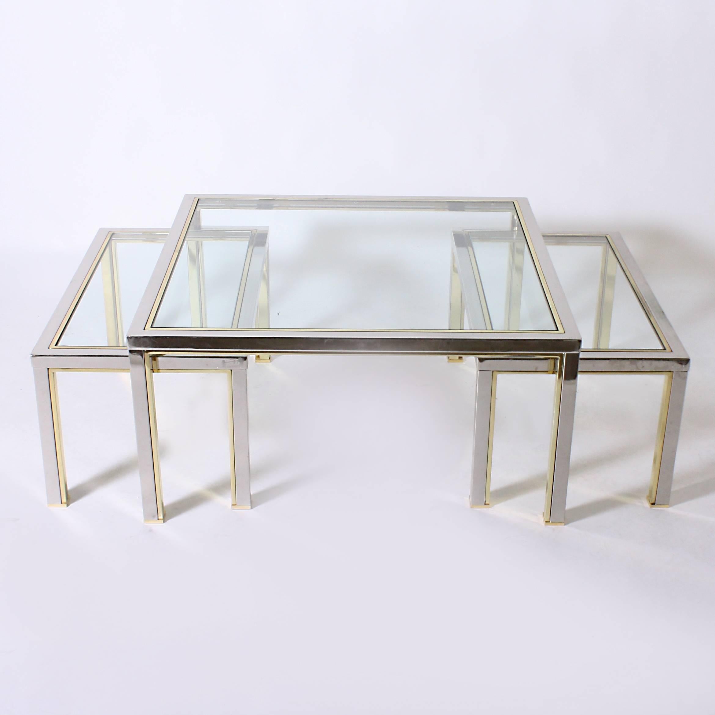 Set of three brass and nickel nesting coffee tables in the style of Romeo Rega
Large table: 34 3/4” square X 16 3/4” H
Small tables: 30” W X 17”d X 14” H.
 