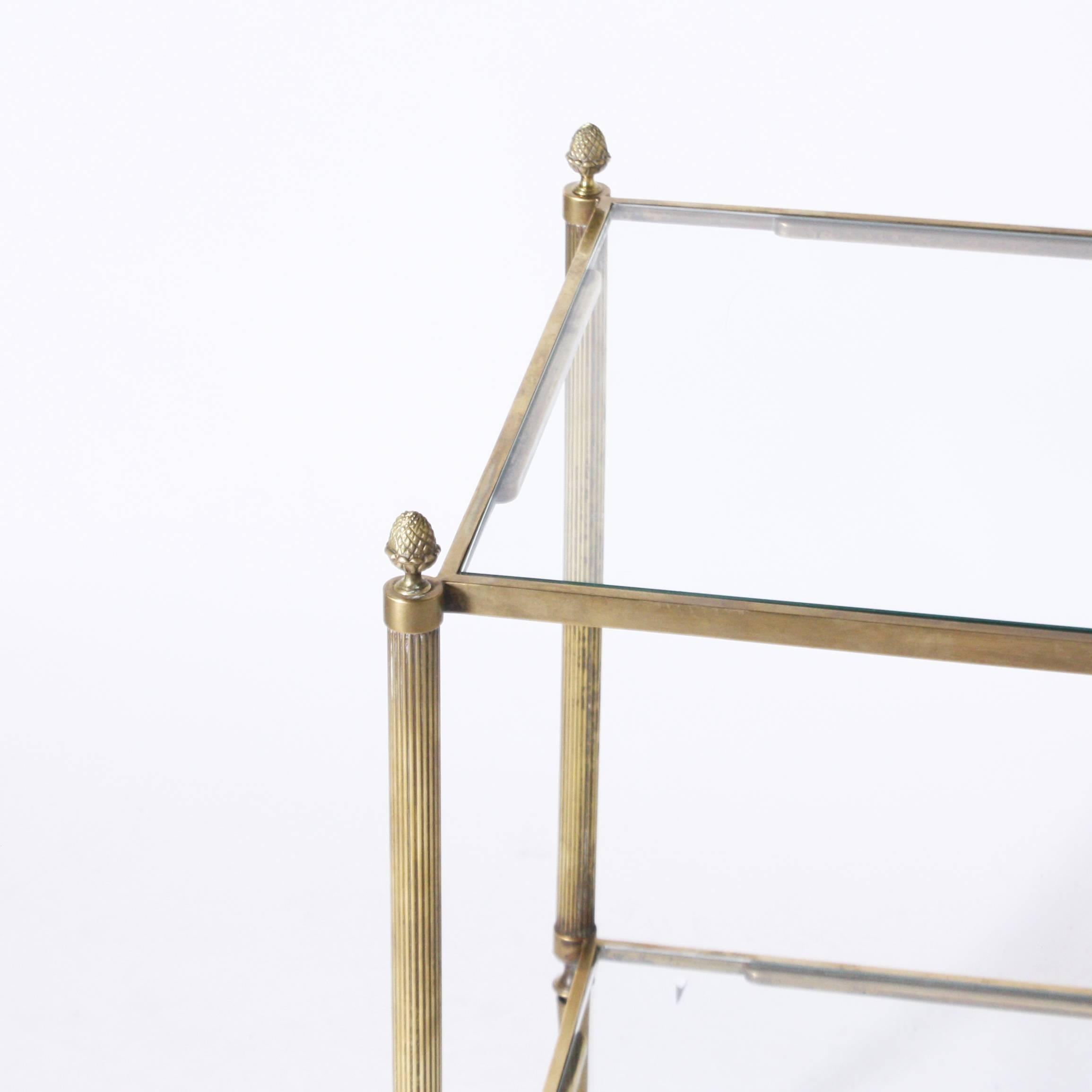 Italian brass bar cart with glass shelves and wheels.