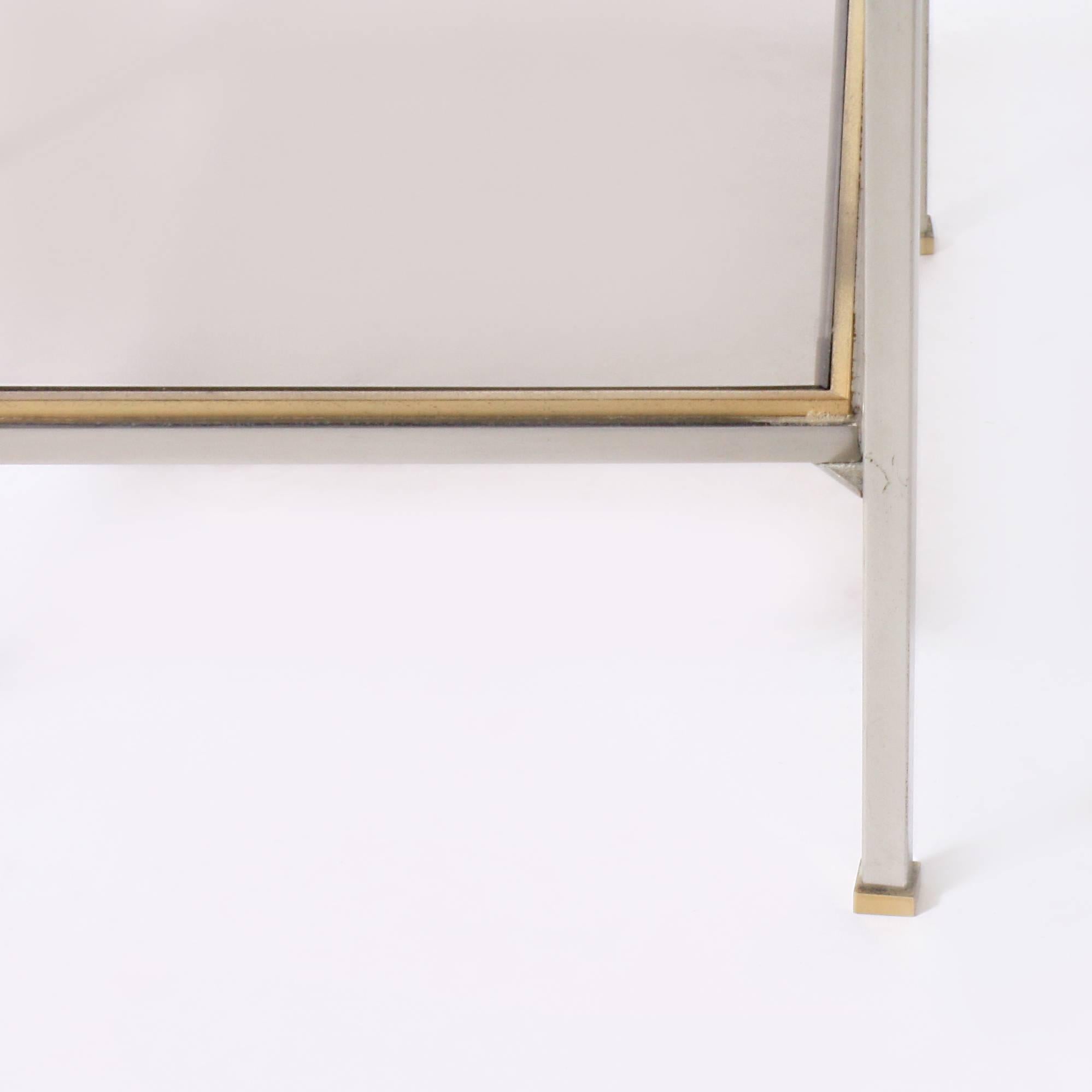 Nickel and brass cigarette table with glass shelves.