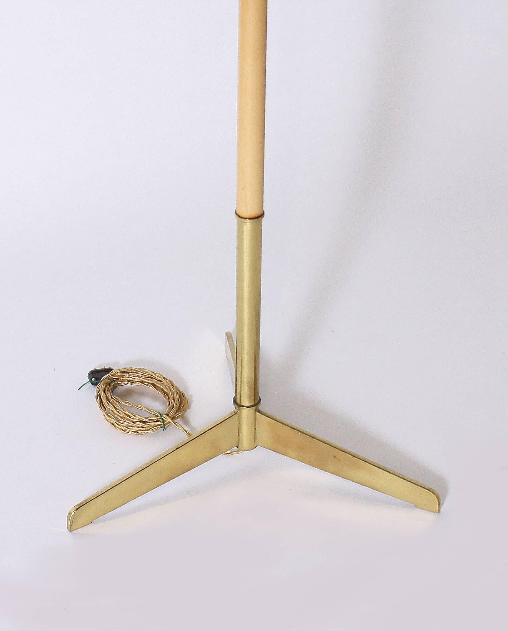 This beautiful Italian floor lamp has a light wood base with brass details and a brass base. This lamp is finished with a gold French silk twisted cording and an ivory linen shade.