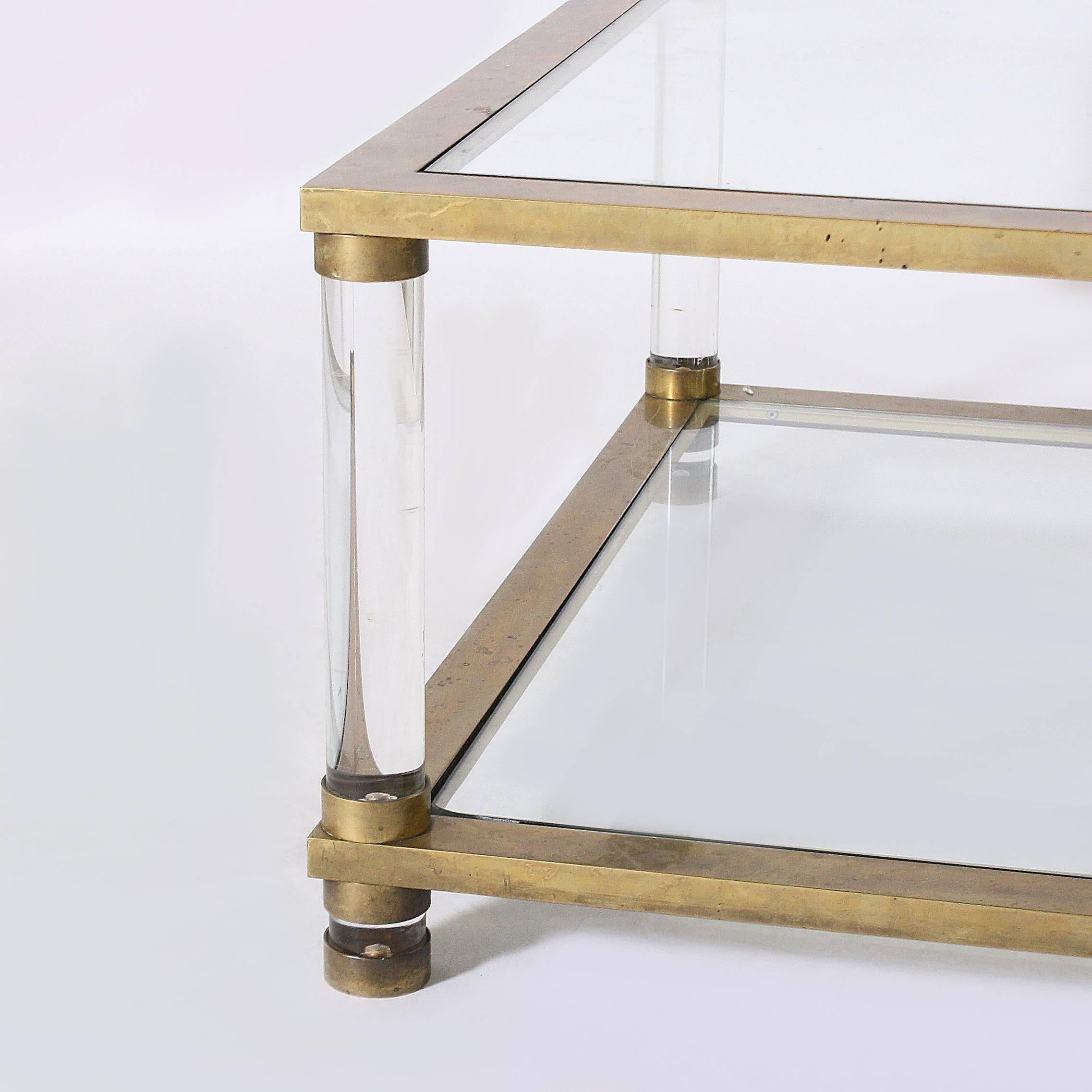 French brass coffee table with round Lucite legs and clear glass tops, circa 1970.
    
