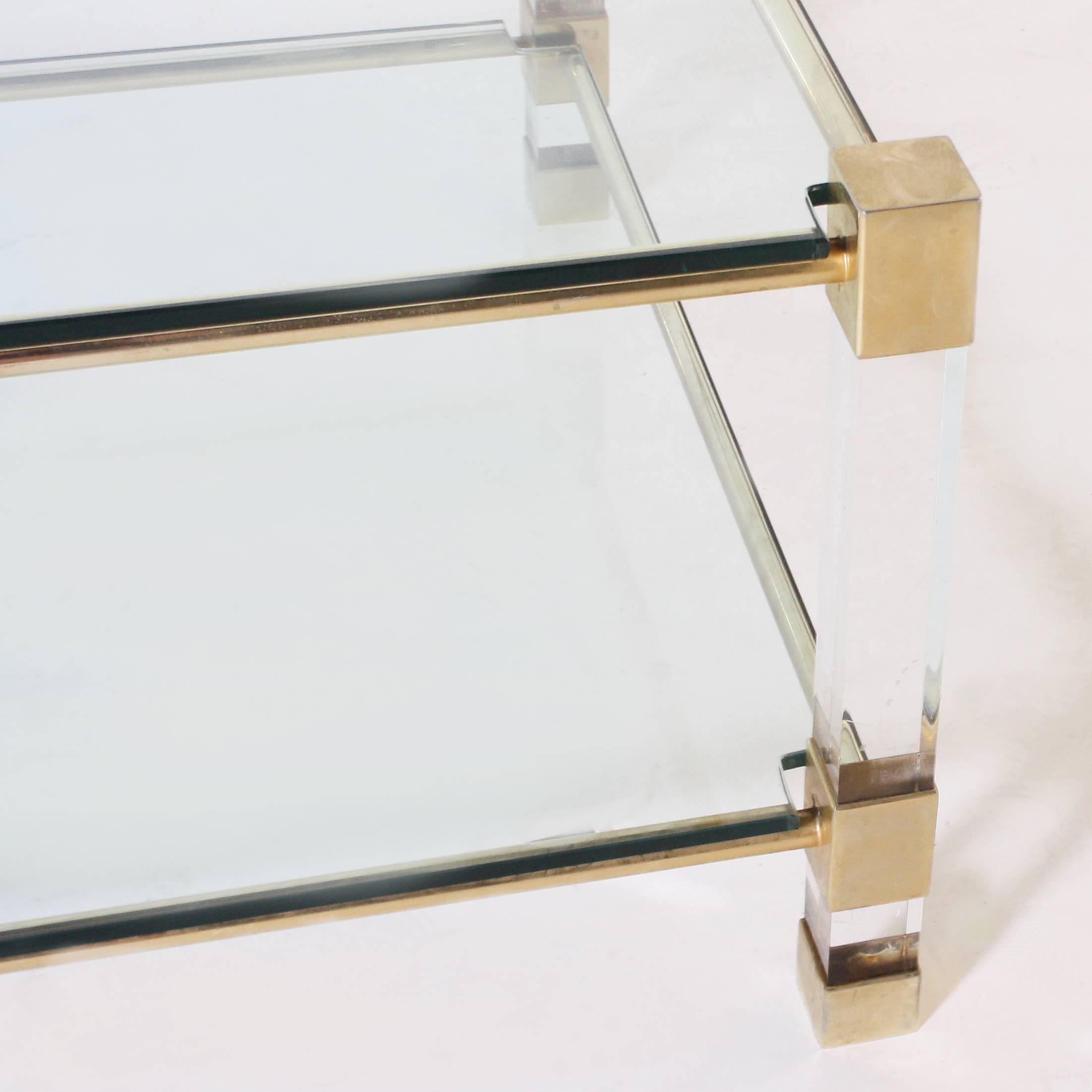 Brass coffee table with square Lucite legs and clear glass tops, circa 1940.
  