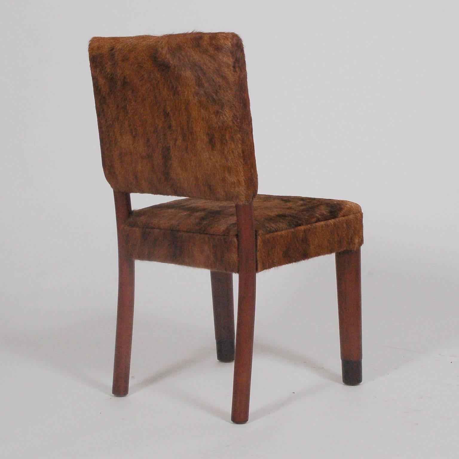 Armless occasional chair with rounded front legs and curving back legs made of stained maple. Newly upholstered in cowhide. Made by Cavalier.