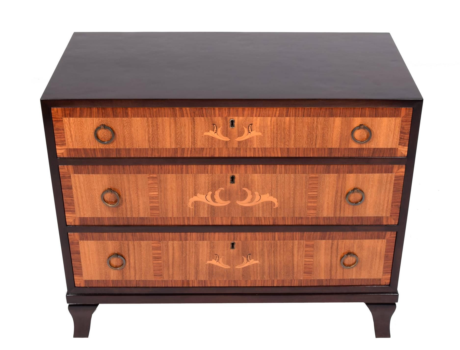 1940s chest of drawers, stained birch case with exotic wood drawer facings, zebra wood and fruitwood inlaid decorations. Neoclassical solid brass drawer pulls.