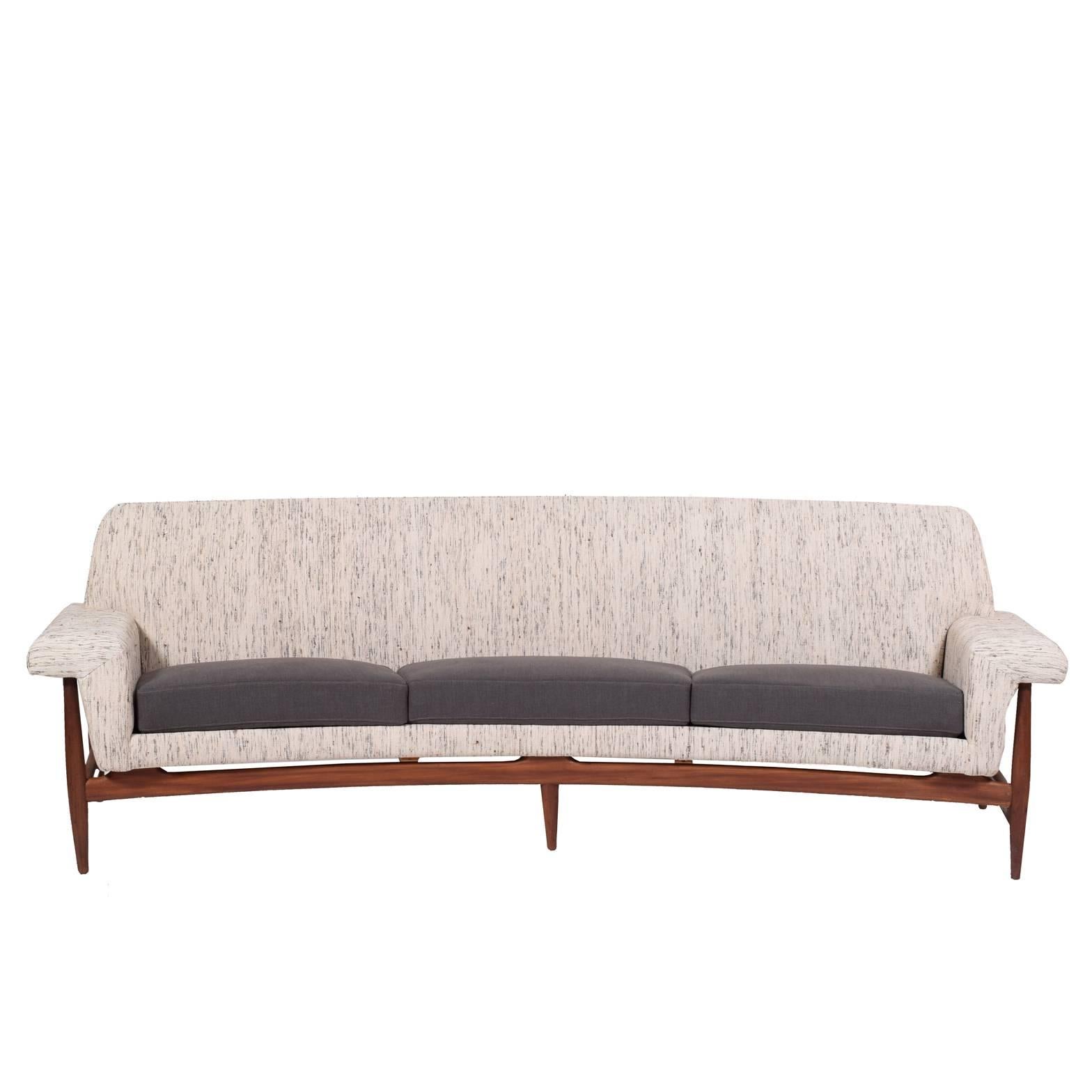 Long sofa curved sofa with three upholstered seat cushions and fully upholstered body. Solid teak exposed frame and legs. Designed to accommodate his Capri table. Year of design, 1958.
Made by Trensum.