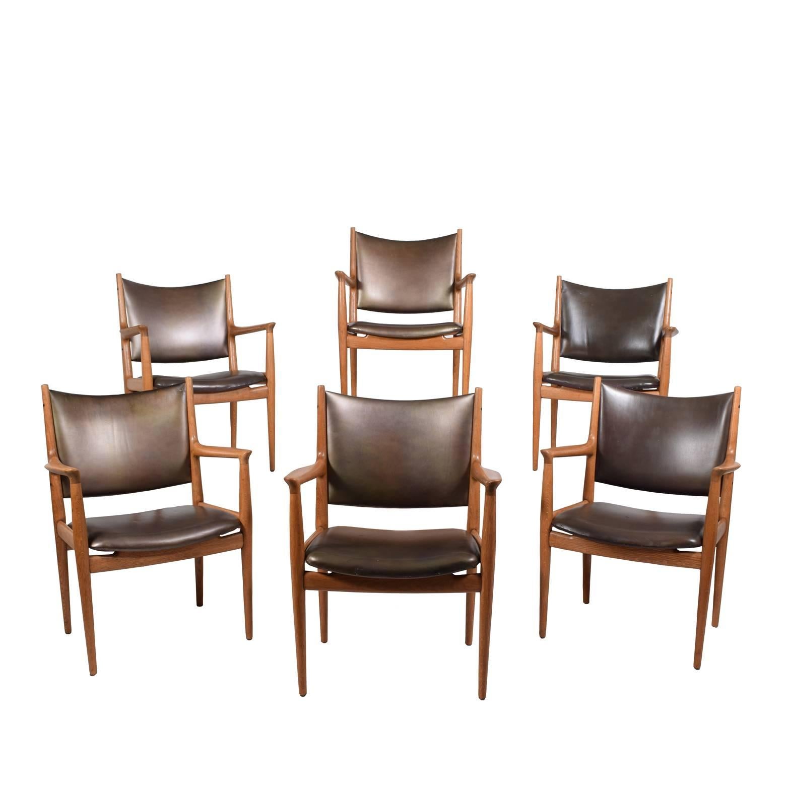 Solid oak and original leather upholstery. Set of six armchairs, designed in 1962.
 Measures: Arm height 27