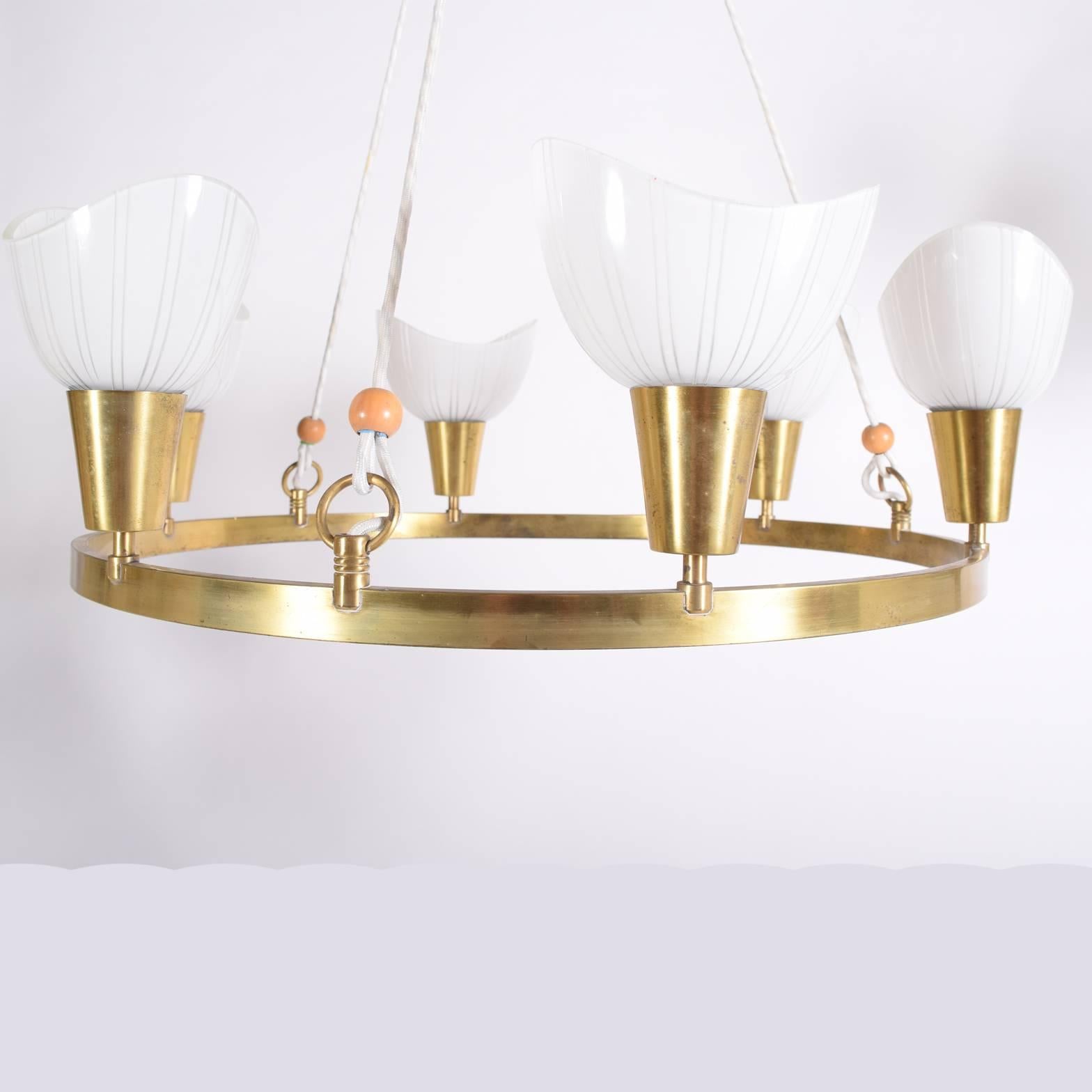 Six upright glass shades; suspended solid brass ring; signed Lyfa on the sockets.