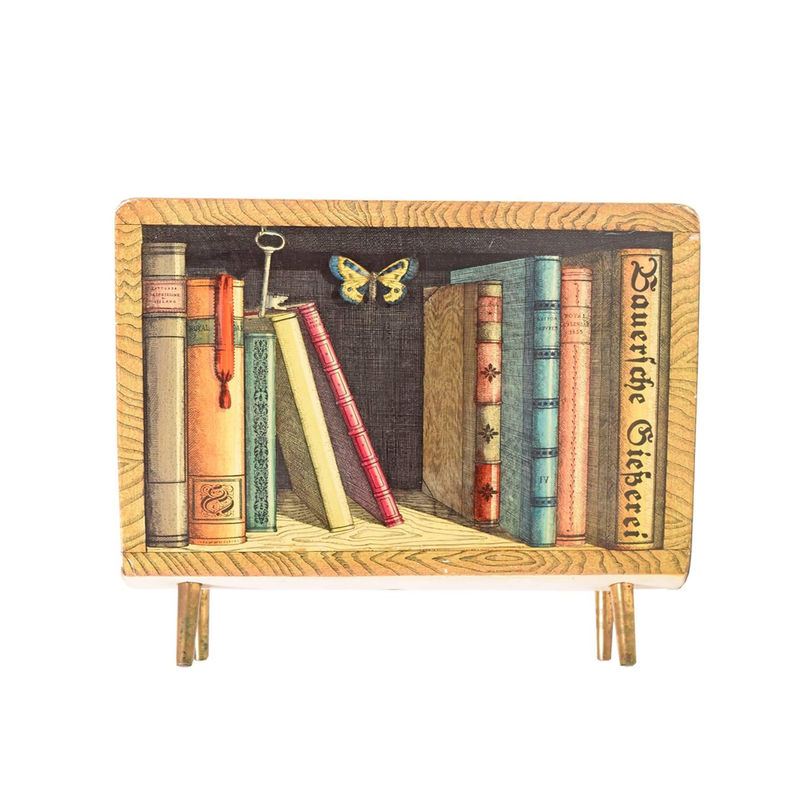 Magazine rack decorated with old books and butterfly on both sides, marked with early Fornasetti label. Pictured on page 183 FORNASETTI Designer of Dreams. Made of plywood and brass.