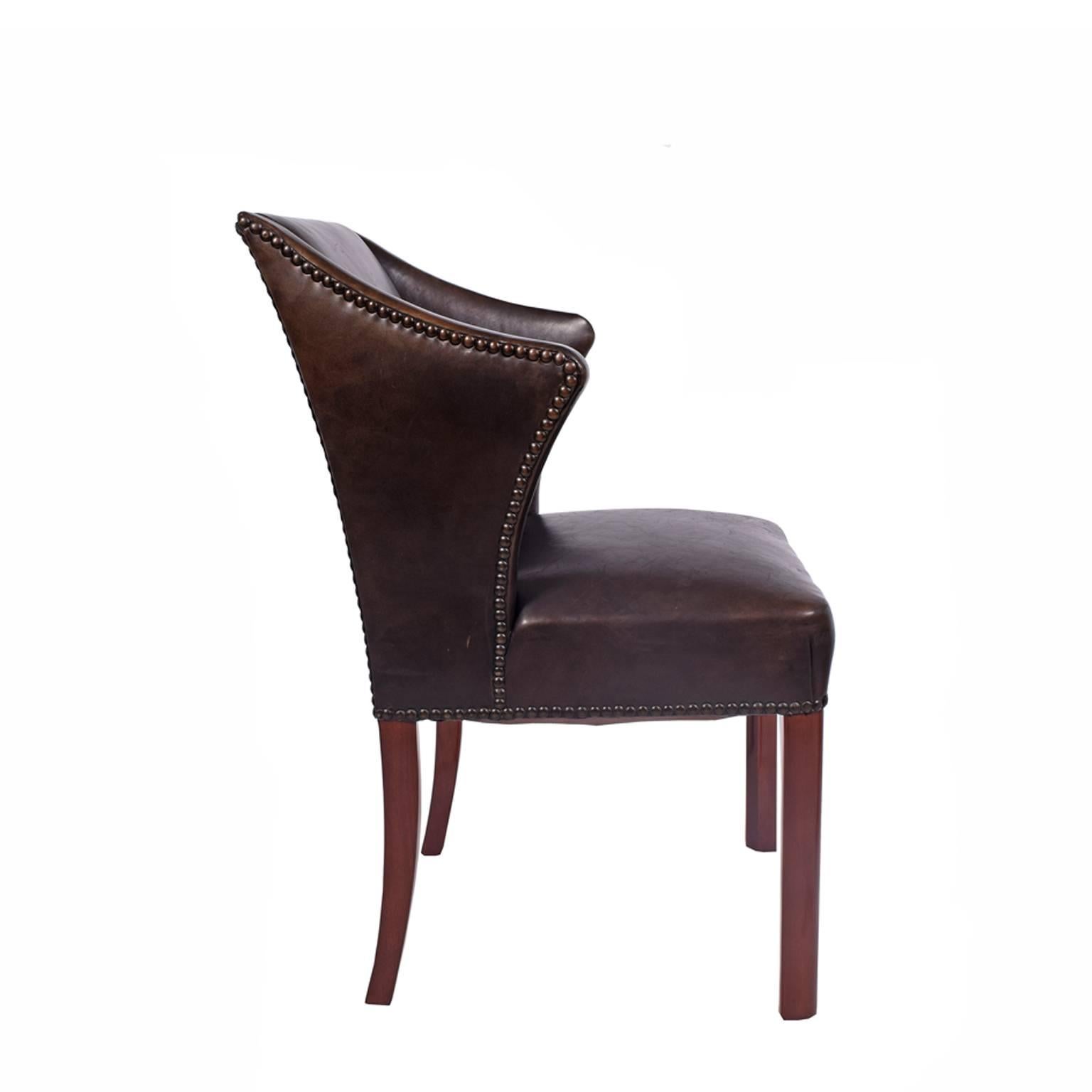 Armchair features black leather, spring seat and mahogany stained beechwood legs. Great looking piece in the style of Frits Henningsen and Fritz Hansen from the 1940s.