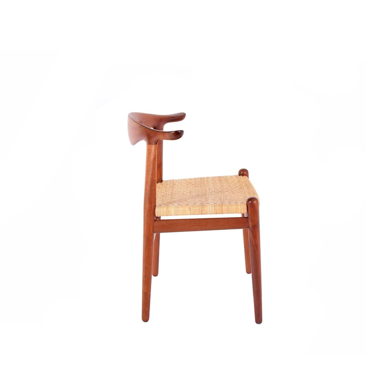 Original production Johannes Hansen solid teak cow horn chair with rosewood inlay back and cane seat. Retains labels from cabinet maker.