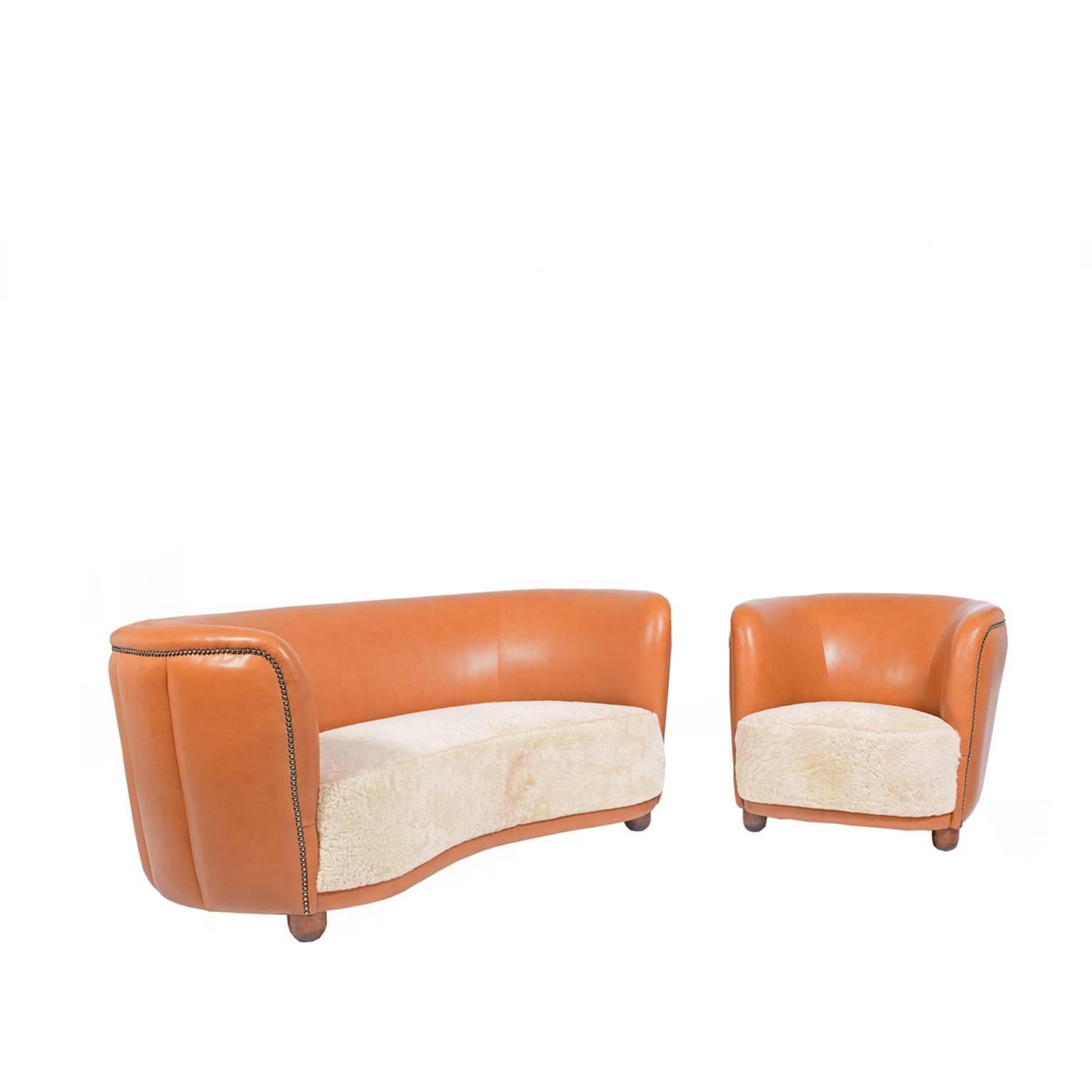 Free-form, two-seat sofa and easy chair newly upholstered in natural leather and sheepskin. Design attributed to Flemming Lassen.

Chair size:
W 30
H 26
D 31
Sh 16.