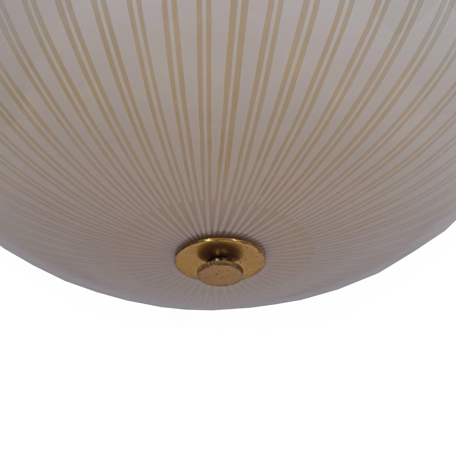 Sand blasted bowl shaped glass shade with clear lines and inner diffuser of yellow glass with brass suspension rod. Three interior light bulbs.