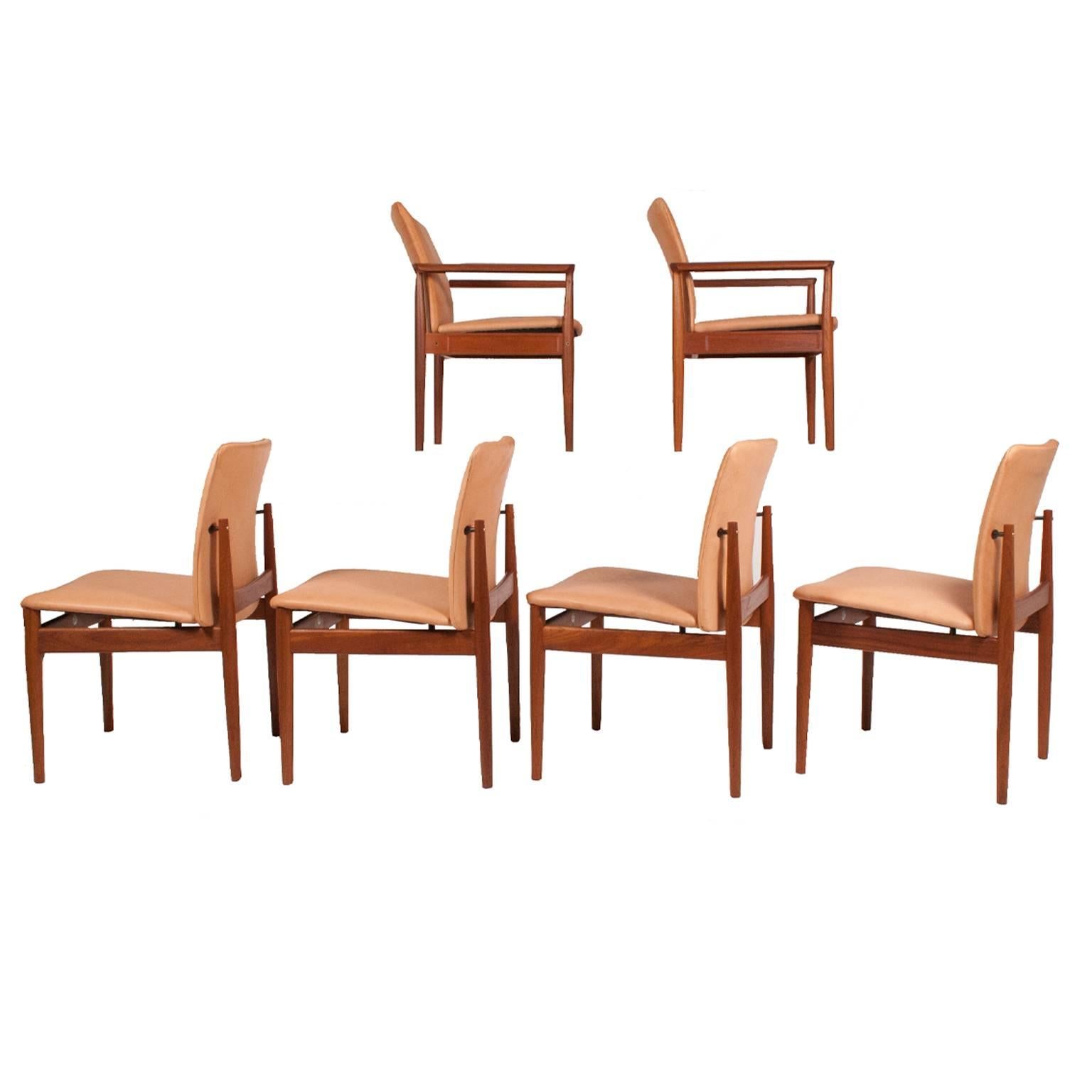 Two armchairs no. 209, one early production, one later production and four side chairs, no. 191, solid teak and natural leather. Side chairs have brass spacers to the back. Made by France and son, armchairs size 32