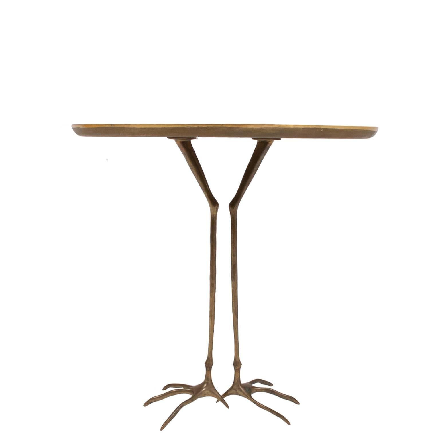 First production of table from the artist designed ultra-mobile collection. Top is gold leaf over wood with bird footprints, base is cast bronze in the shape of bird legs. Originally designed in 1939 by Surrealist artist Oppenheim, it did not go