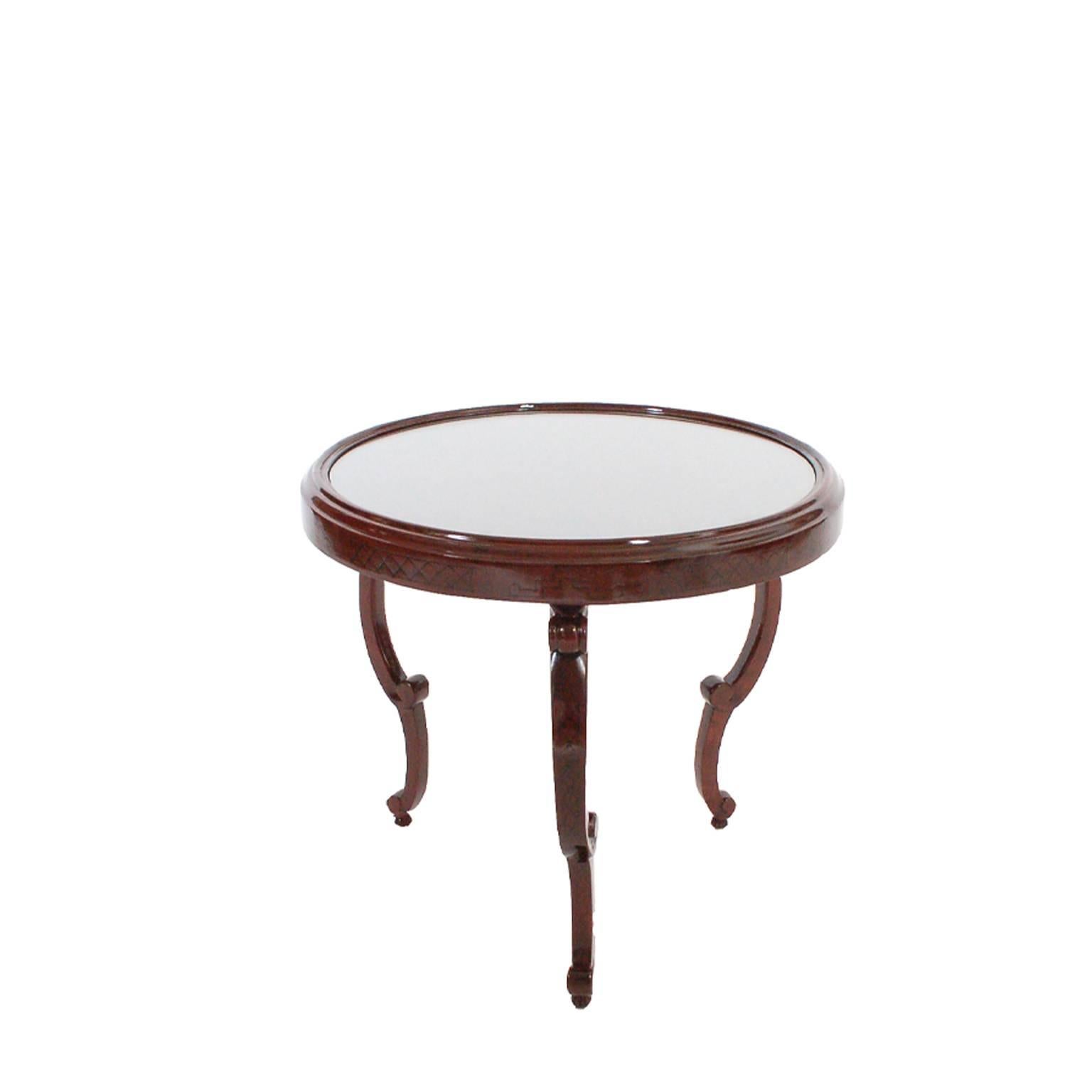 Mahogany-stained birch with ebony inlaid designs. Three scrolled legs and glass insert in top. Restored.