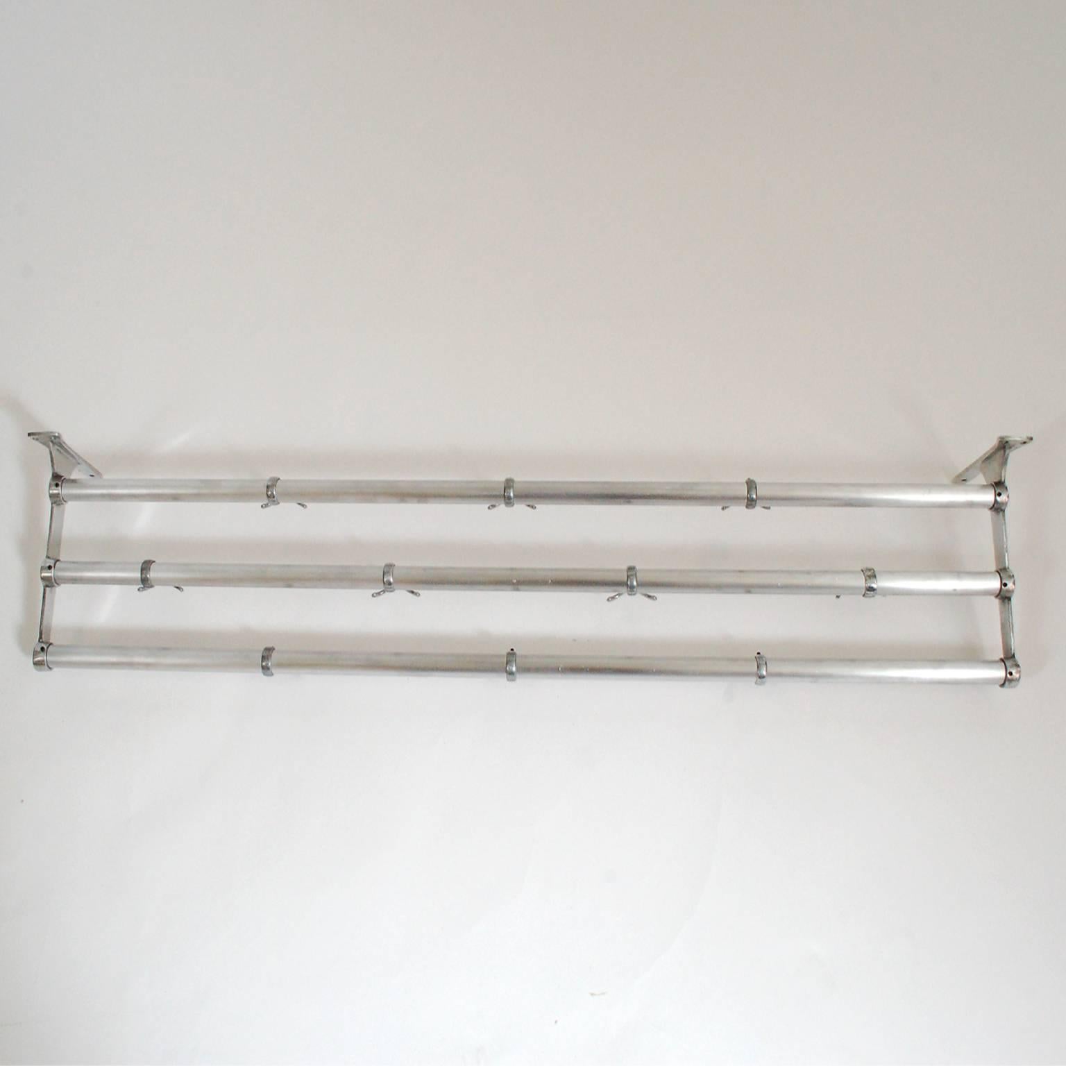 Three rod wall-mounted coat rack, with ten two-sided and adjustable hooks. All aluminum. First half of the 20th century.
