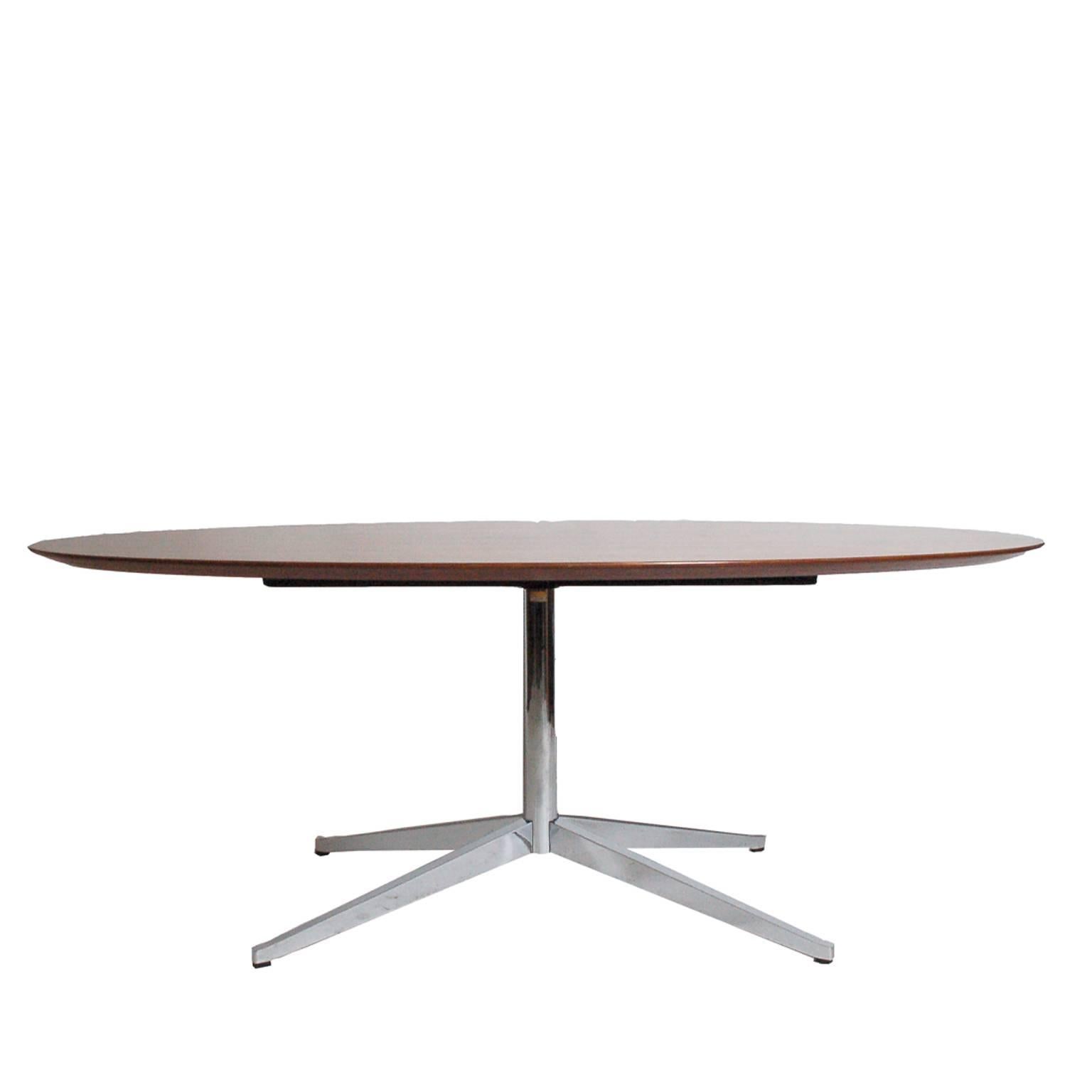 Beautifully grained rosewood top on polished chrome steel four prong pedestal base. Use as table or writing desk. Manufactured by Knoll.