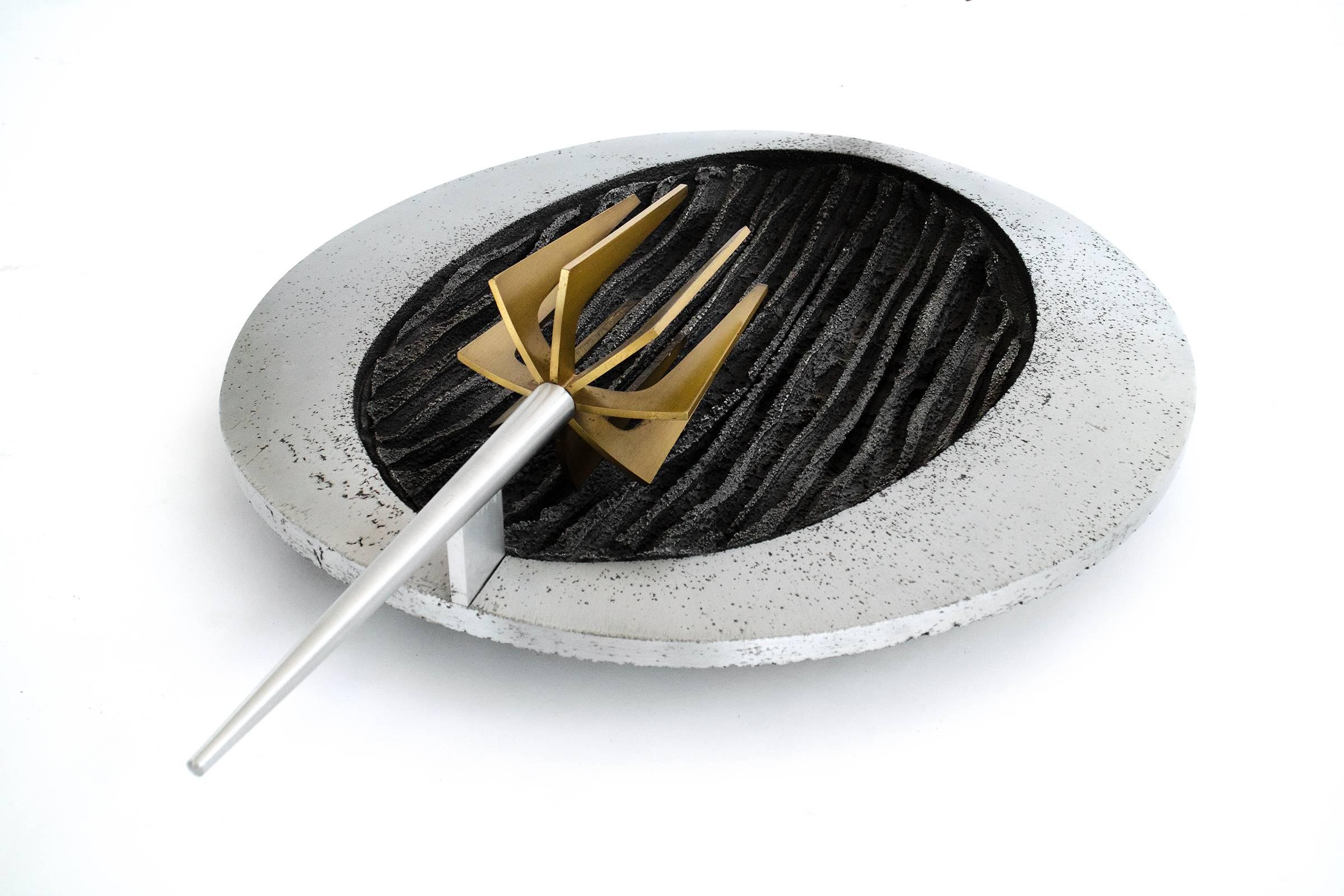 Antorcha escultórica de pared brutalista, puede conectarse a la corriente eléctrica o utilizarse como antorcha de vela.
Aluminio fundido con soporte de luz de púas de latón anodizado estriado y relieve vertical oscurecido.