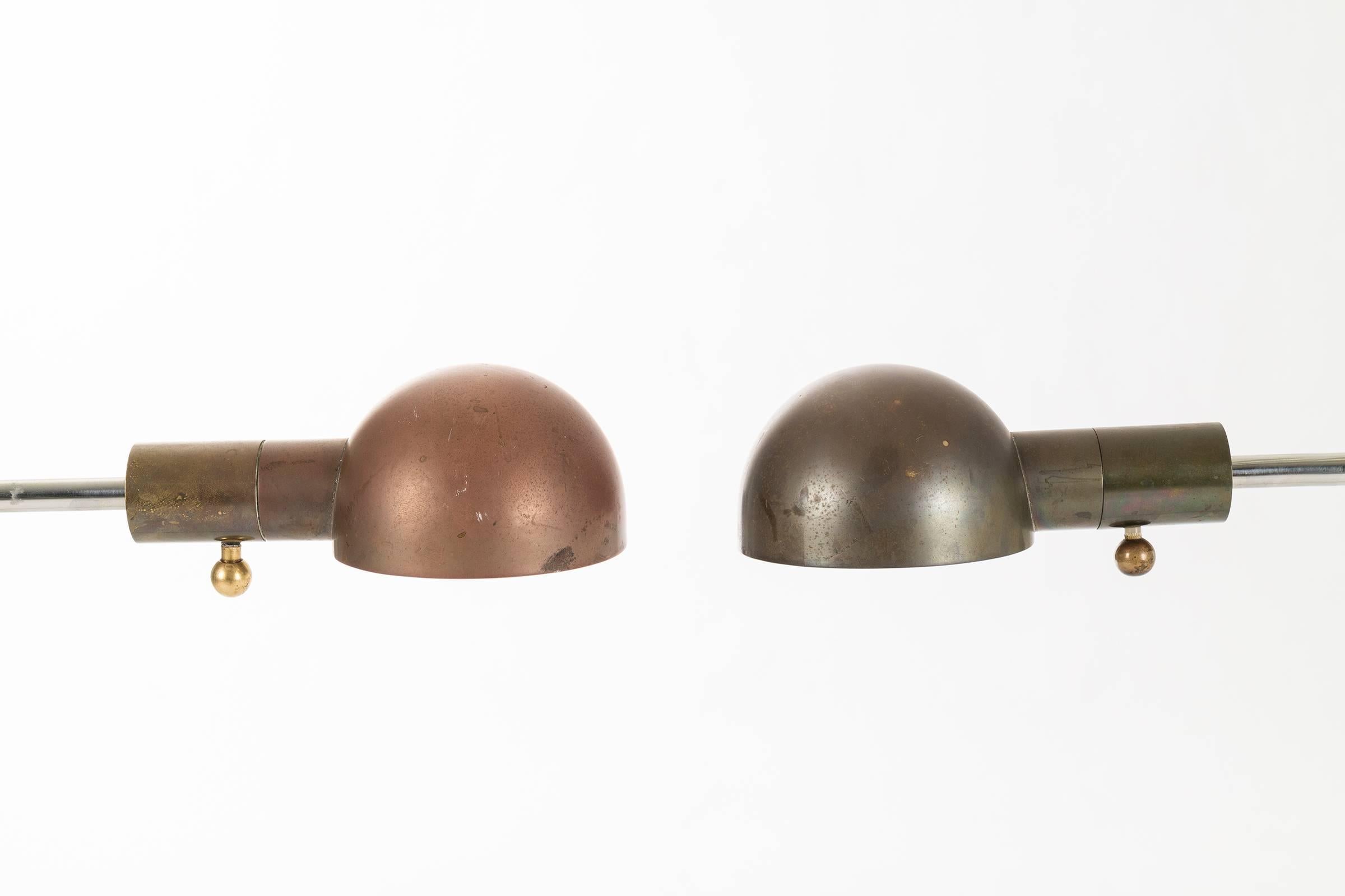Pair of floor luminaires by Hartman. Can be adjusted in many directions. 33 inches minimum height and 49 inches maximum height. The brass shade swivels and is equipped with a dimmable socket. Different toned patinas on shades.