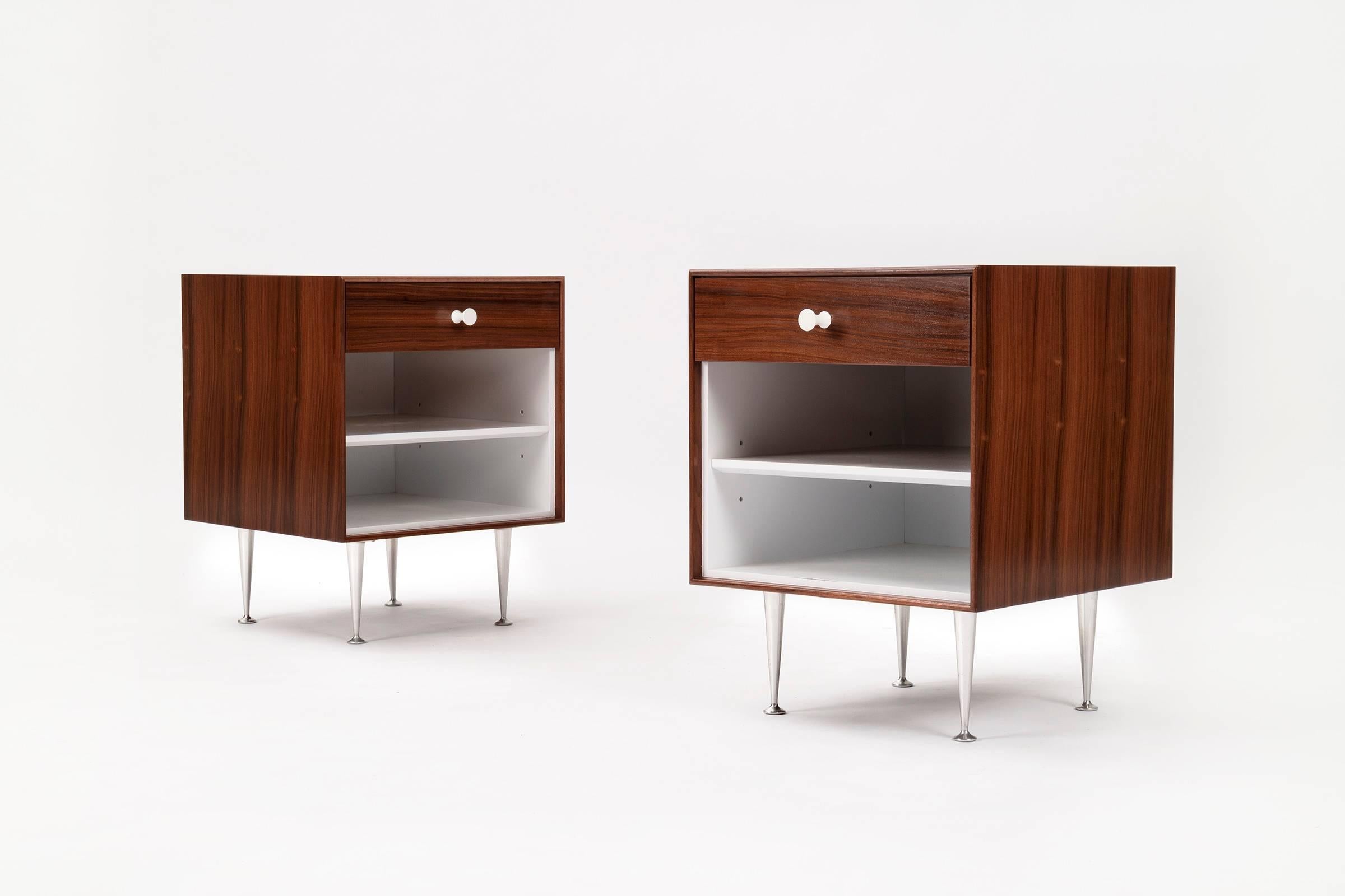 Nelson for Herman Miller thin-edged  rosewood  nightstands.
Features porcelain knobs and tapered spun aluminium legs.