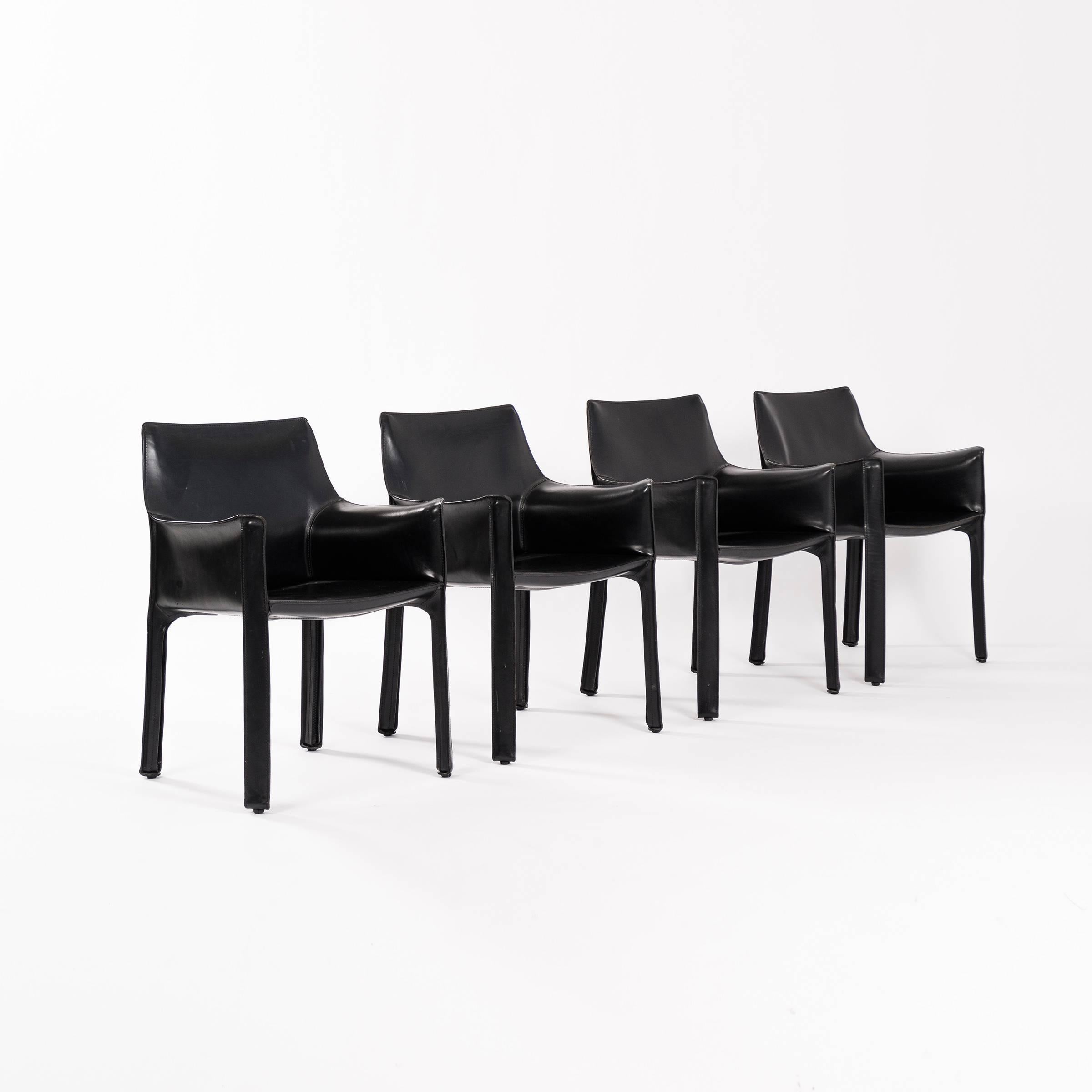 Set of four 413 CAB dining chairs in black saddle leather. Excellent vintage condition.