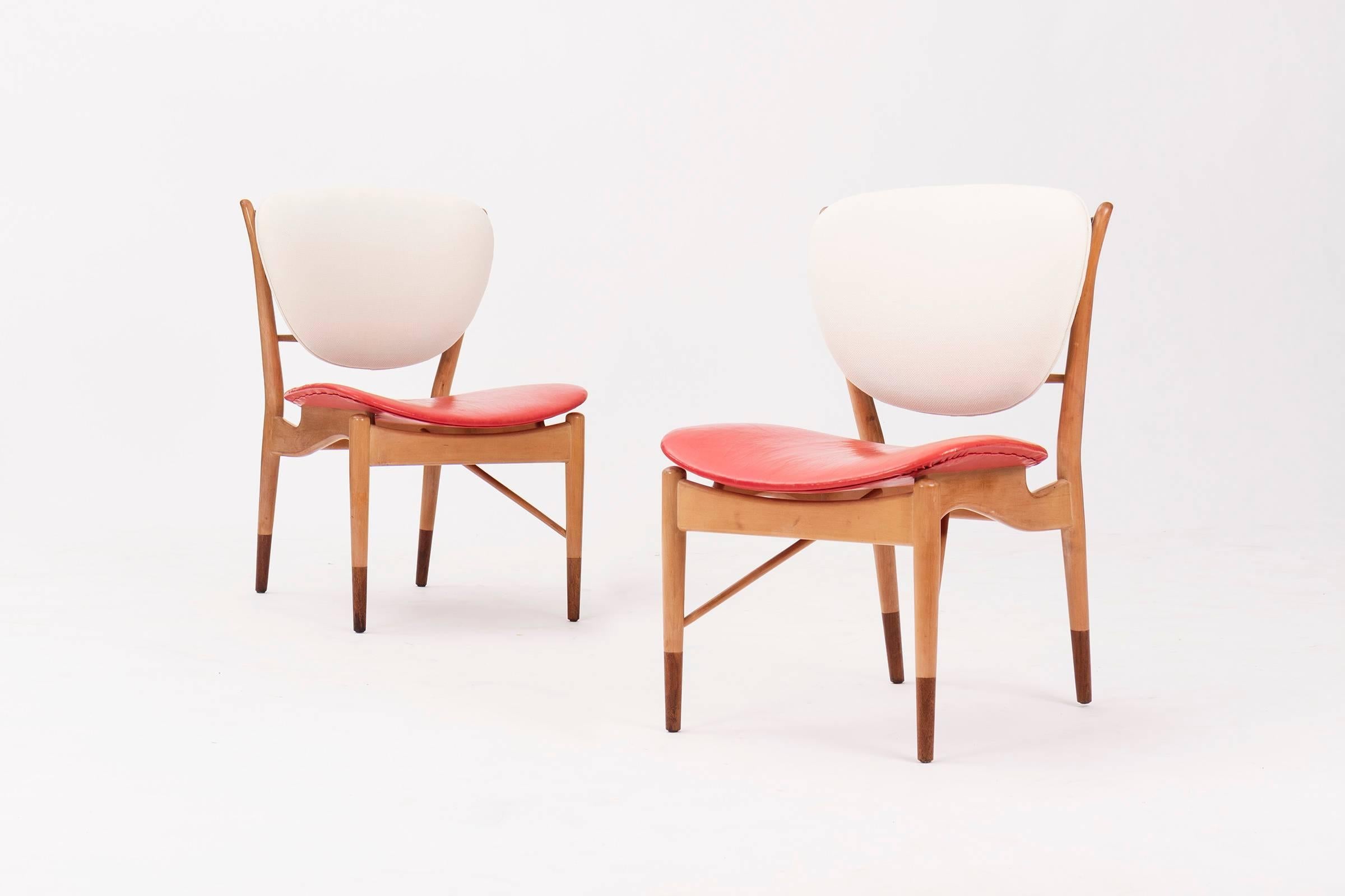 Finn Juhl for Baker Furniture Company. A pair of model NV 51 side chairs with solid walnut frame with original red leather seat and newly upholstered back.
Seat showing great patina and crazing.