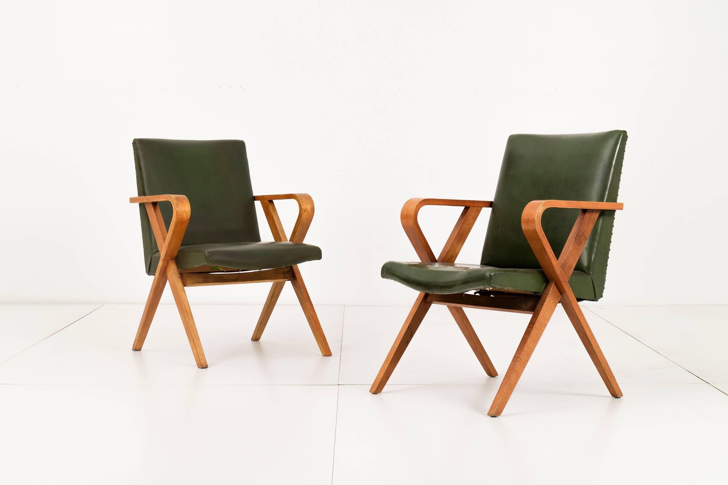 Pair of Henry glass armchairs. Green leather seat with metal rivets alining the back. Angular bentwood frame with curved armrest.