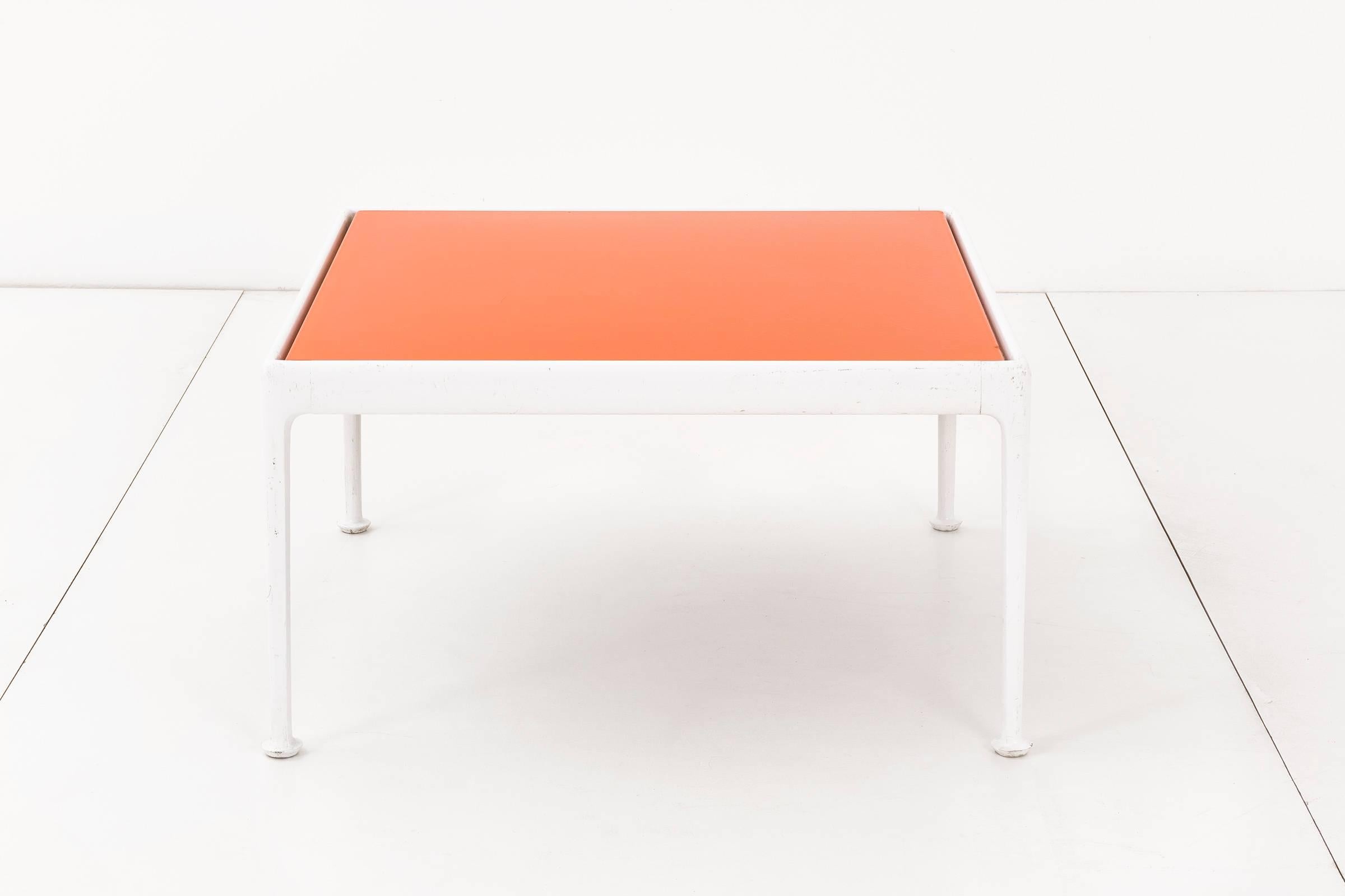 Richard Schultz outdoor coffee table for Knoll. This table has a white powder-coated, cast and extruded aluminum frame with an orange enameled porcelain on steel tabletop. The table has a weather resistant finish and a slight gap between the top and