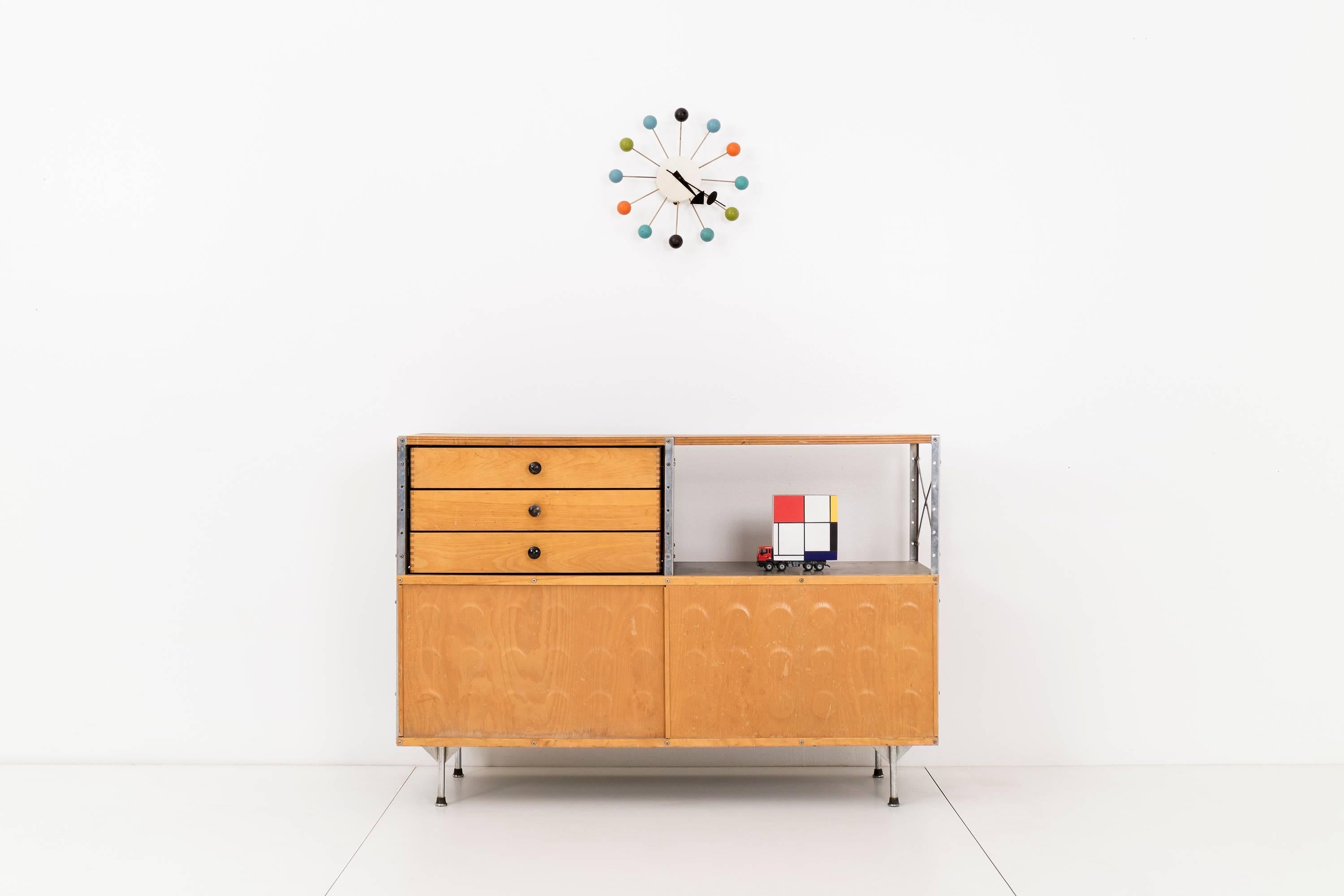 Charles and Ray Eames for Herman Miller. Model 220-N. This storage unit has a zinc-coated steel frame, maple-top and painted hardboards. Features three drawers and sliding preset plywood dimple doors to conceal storage. Top is damaged due to water