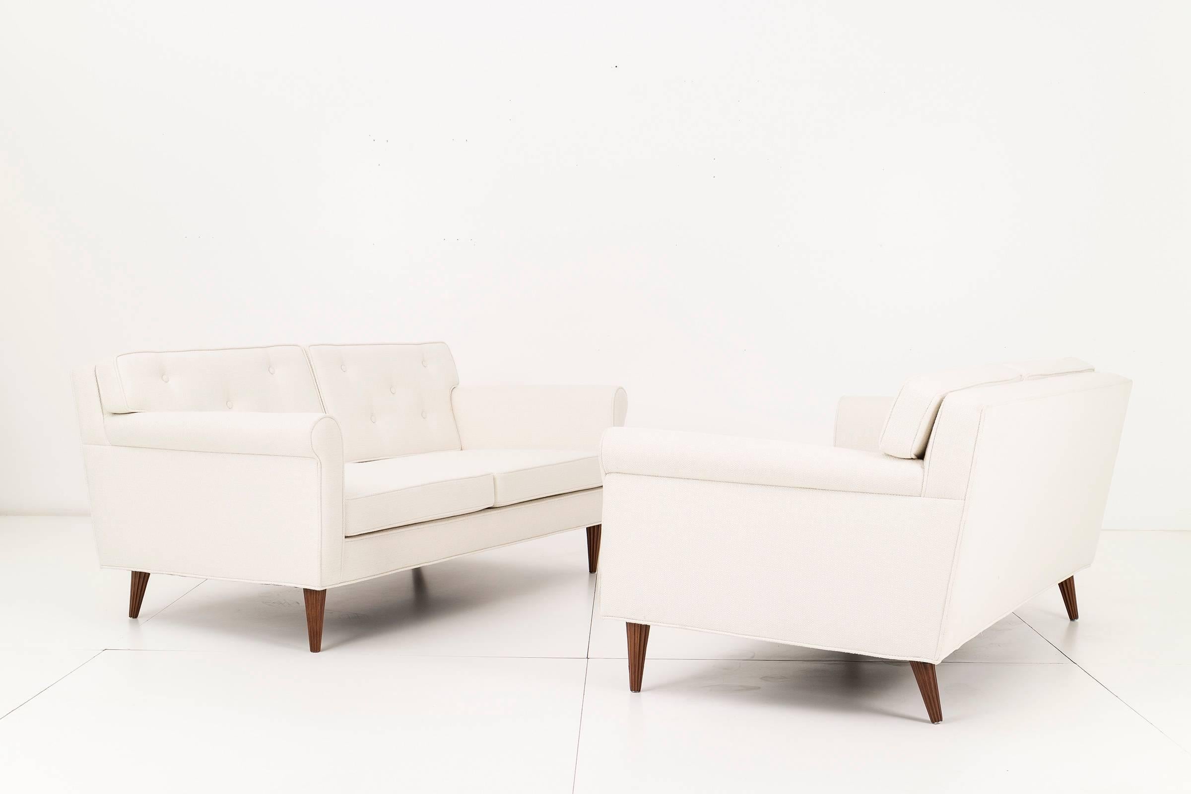 Wormley Settees for Dunbar. Features button-tufted back cushions, reupholstered with Great Plains cotton-poly.
Solid mahogany fluted legs with scroll arms.