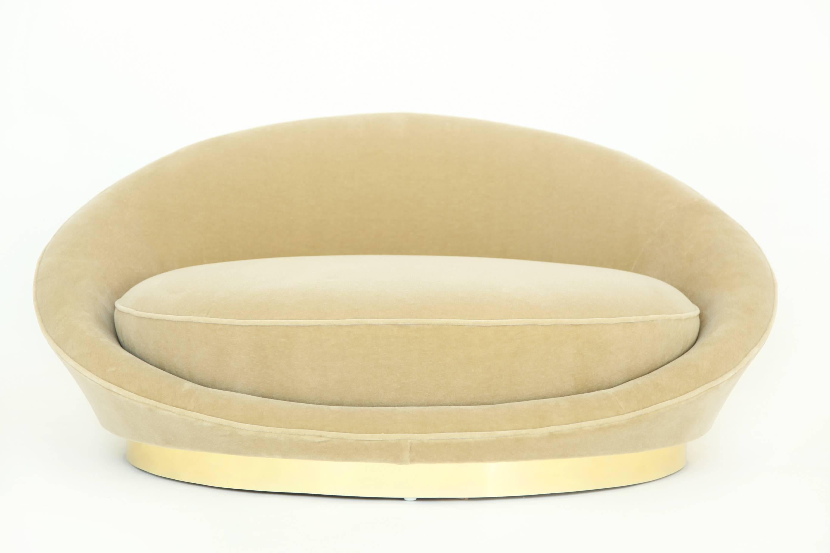 Milo Baughman for Thayer Coggin; oversized chaise lounge for 1-2 people.  Curved barrel back and spring cushion wrapped in a beige/champagne mohair, rests on top of a brass plinth base.