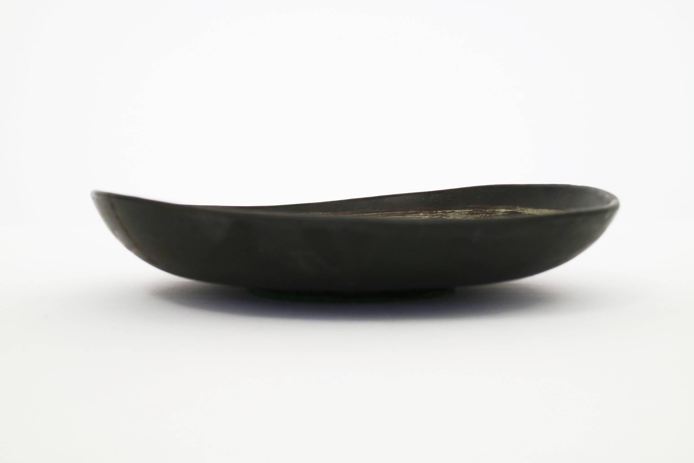 Ceramic dish, showing tones of yellow black and white with Abstract Fish figure..