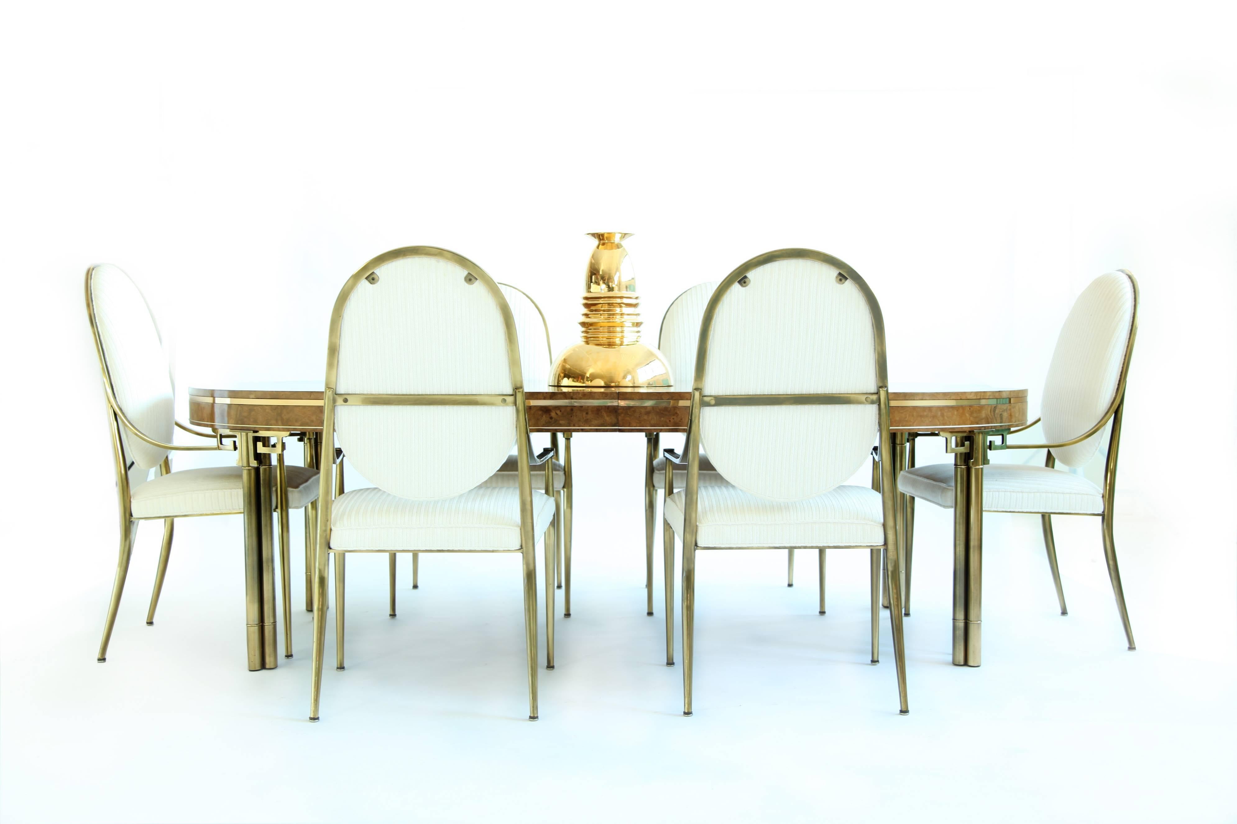 Mastercraft dining table, brass legs with Greek key detail, bookmatched English elm high-polished top inlaid parquetry framing details (shown) and double banded brass trim edge, flat and rounded.
Table dimensions (no leaves) 47