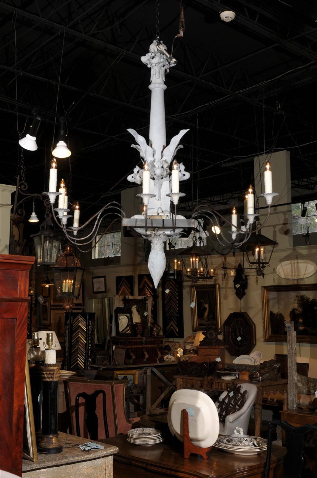 Early 20th century zinc eight-light chandelier, the floriform central support with sprouting acanthus leaf decor terminating in a square center from which four scrolling arms spring on each side.