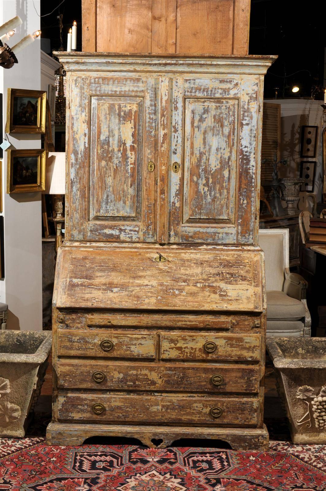 This Swedish Karl Johan style painted heart of pine slant-front secretary from the 19th century features two doors over five drawers. The general appearance is simple and elegant, made of clean, pure lines. The upper cornice is flat and delicately