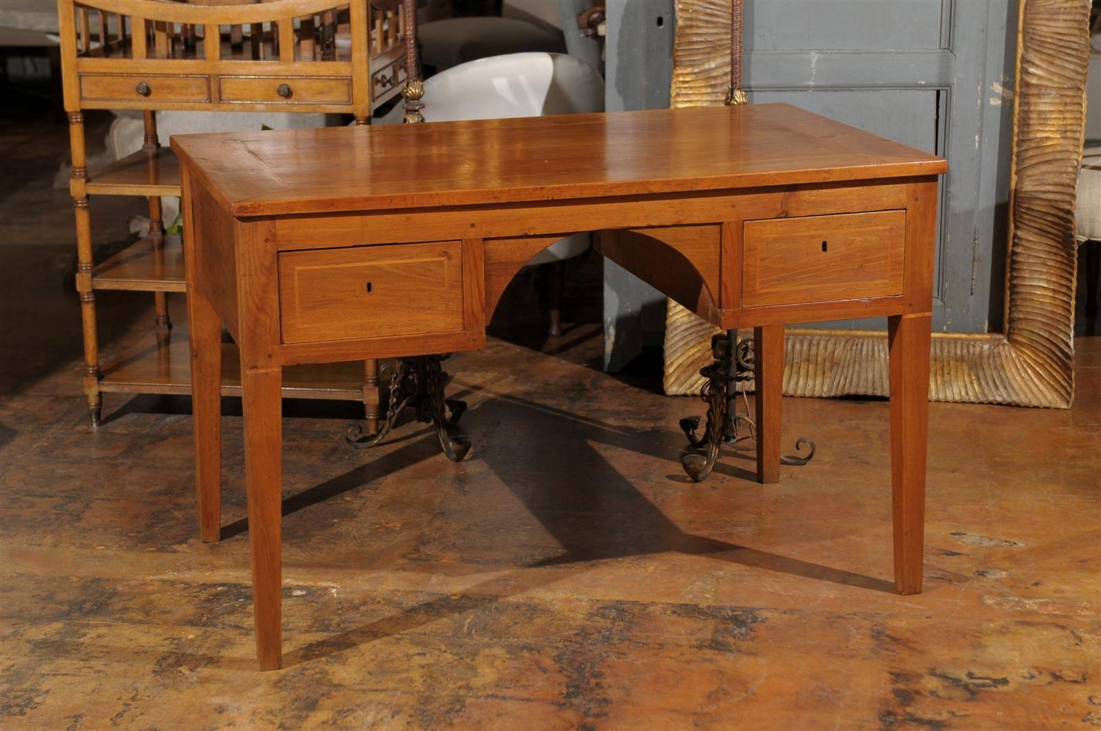 An Italian walnut partner’s desk from the turn of the century with banding, four drawers and arched apron. This Italian narrow partner’s desk from the late 19th century features a rectangular top with quarter veneer and banding over an apron, arched