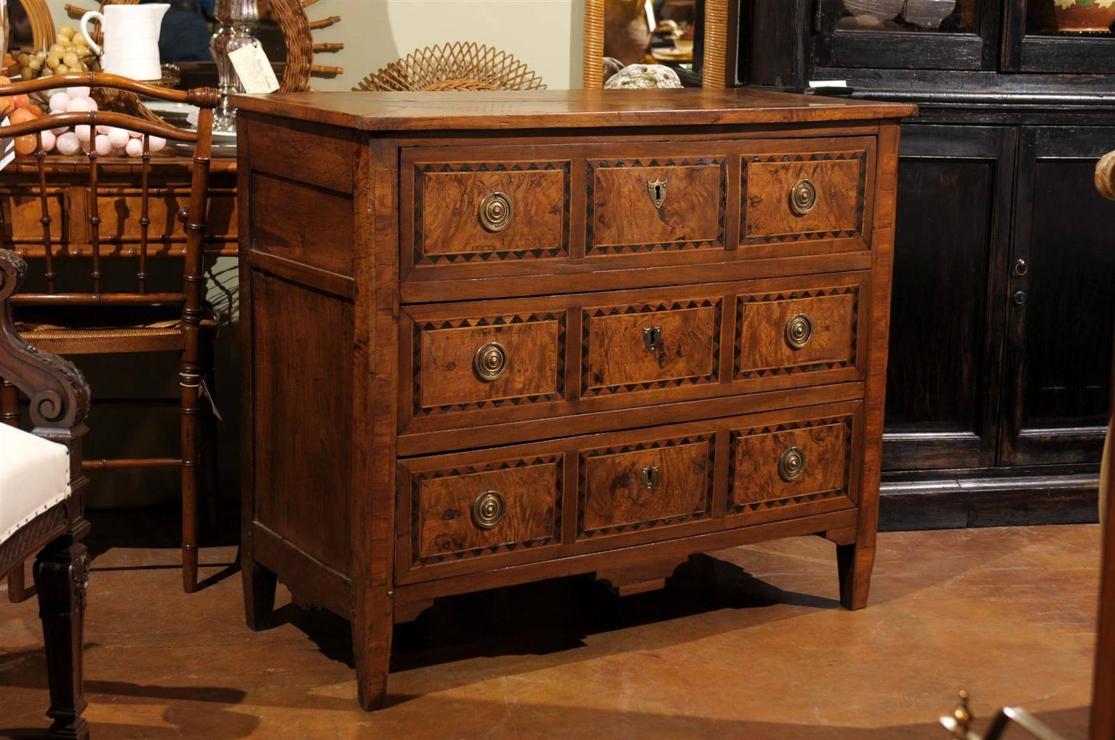 Mid to late 19th century burl walnut commode, the rectangular top surmounting three long drawers, each with inlaid work on three panels, brass ring pulls and escutcheons, all raised on tapering block legs.