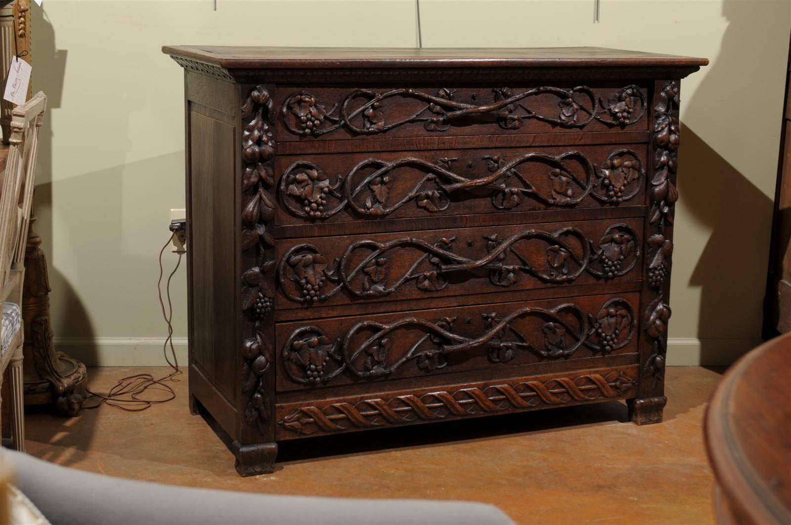 Late 18th to early 19th century Black Forest commode, the rectangular top surmounting four long drawers, each carved with scrolling grapevine and bird motifs, flanked by similarly carved pedestals and apron and raised on straight and scrolling feet.