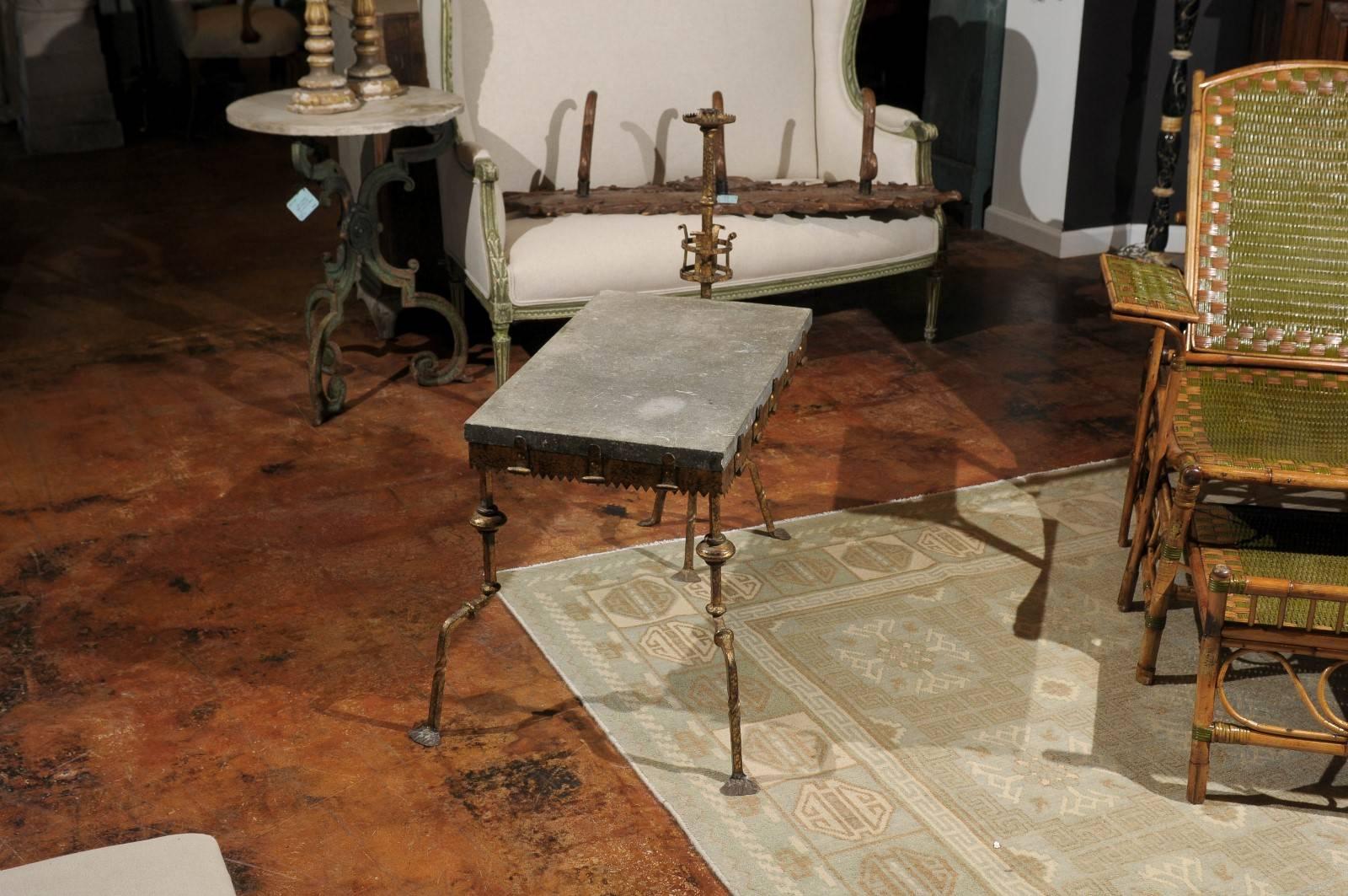 A French industrial iron and slate wine tasting table from the turn of the century. This French wine tasting table circa 1900 features a rectangular slate top supported by a gilt and hammered metal structure. The table top is raised on an unusual