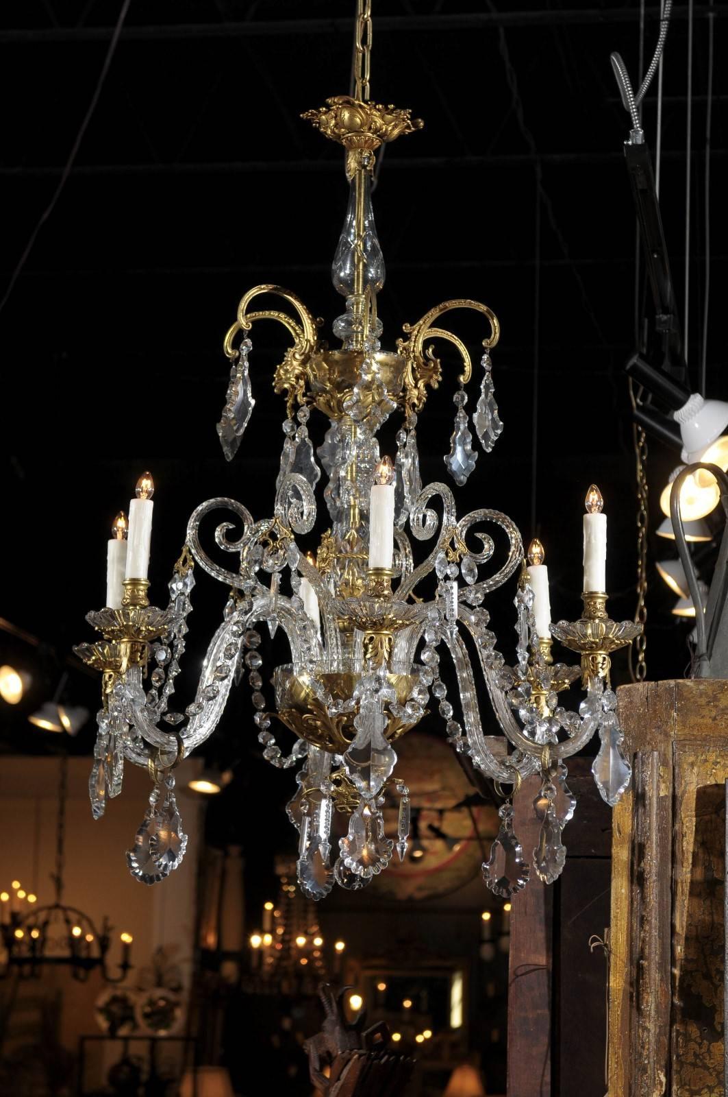 A French rococo style gilt bronze and crystal six-light chandelier from the 19th century. This French six-light crystal chandelier features a central etched glass column with gold mercury glass accents supporting six twisted glass scrolled arms with