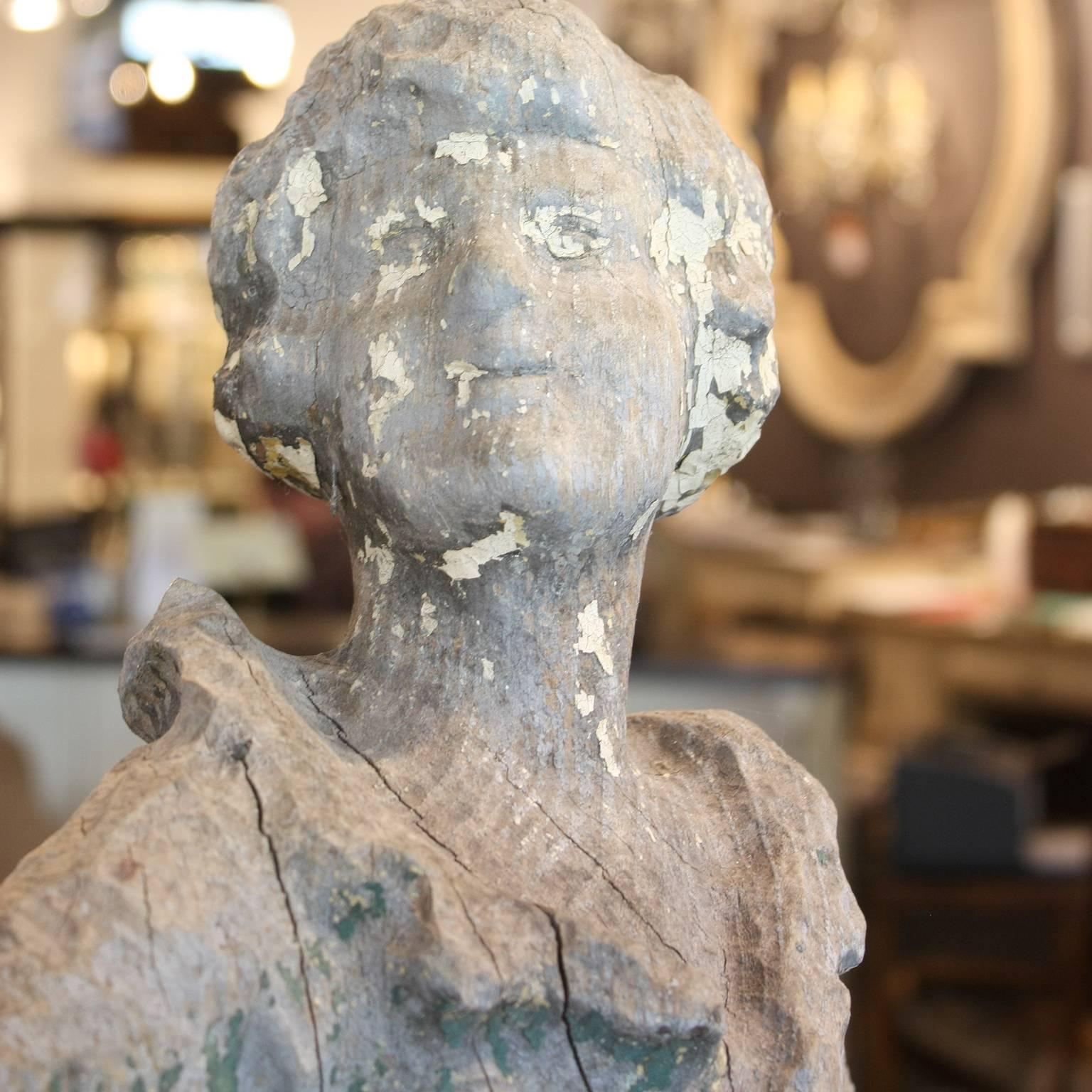 A French 19th century hand-carved sculpture of a young girl with traces of old paint. This French statue depicts a young girl whose determination and self-assurance is communicative. The face is barely defined, leaving us with a feeling of delicious