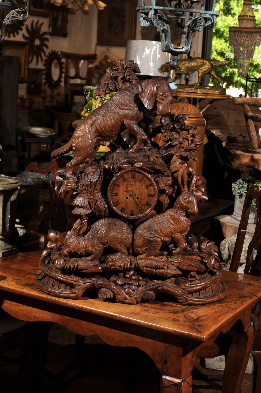 A Black Forest Swiss hand-carved musical clock from the 19th century with hound and hares. This exquisite hand-carved wooden clock was born in Switzerland, traditional home of some of the best clockmakers in the world. In typical Black Forest