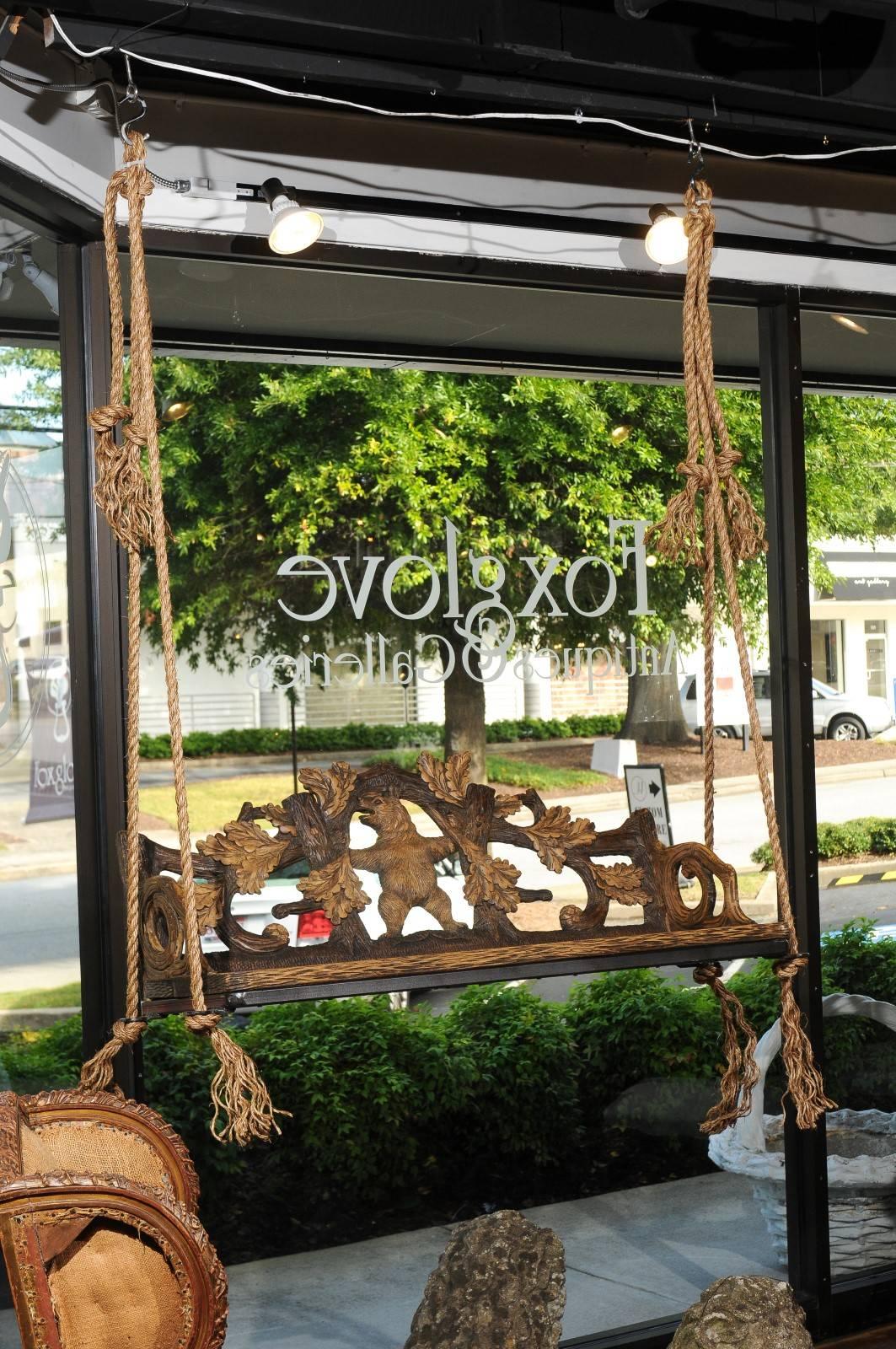 A Black Forest Swiss carved wooden bench from the late 19th century made into a swing. The story of this wooden swing starts in Switzerland during the late 19th century. Made in the traditional Black Forest manner, the bench features a richly carved